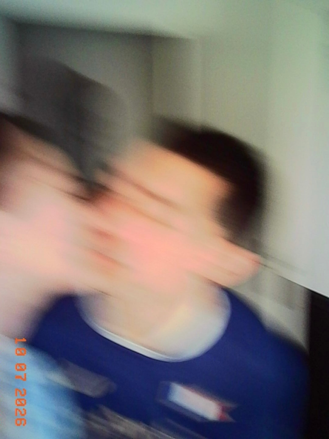 Two people are seen in a blurry motion, appearing to be close together indoors.
