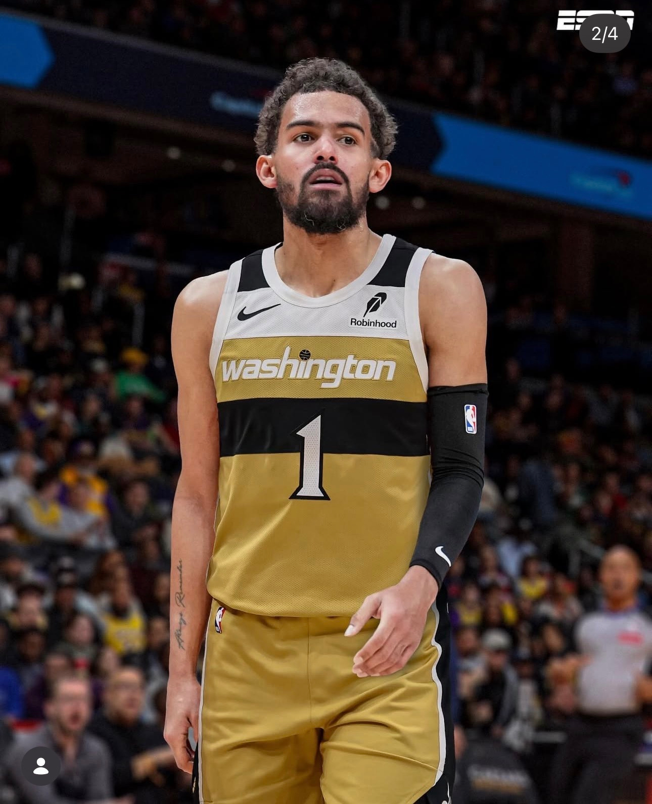 A basketball player in a gold and black uniform is walking on the court during a game.