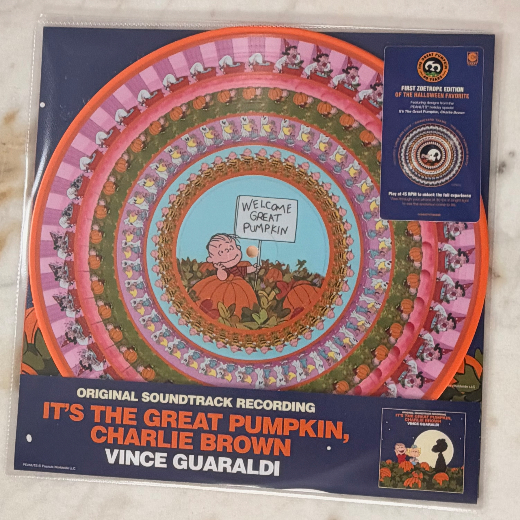 Auto-generated description: A colorful, spiral-themed vinyl record cover features characters from the Peanuts comic strip with Charlie Brown holding a Welcome Great Pumpkin sign, promoting the original soundtrack recording of It's The Great Pumpkin, Charlie Brown by Vince Guaraldi.