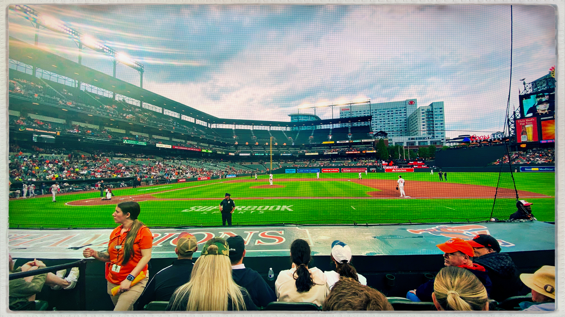 A lively baseball game is taking place in a stadium with a large crowd watching.