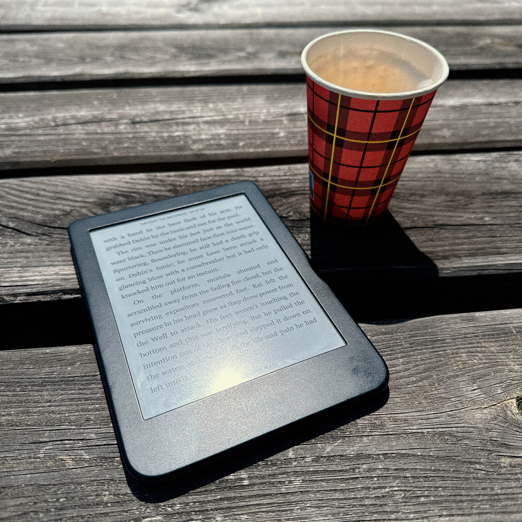 Kobo e-reader and a coffee on a wooden table. 