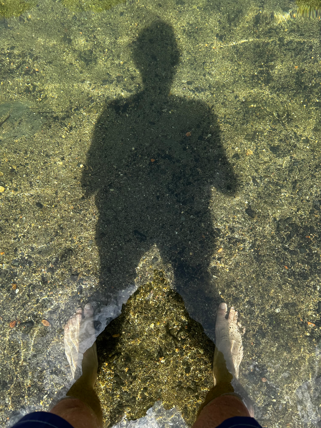 my shadow and me, feet under water, in a small river somewhere in France