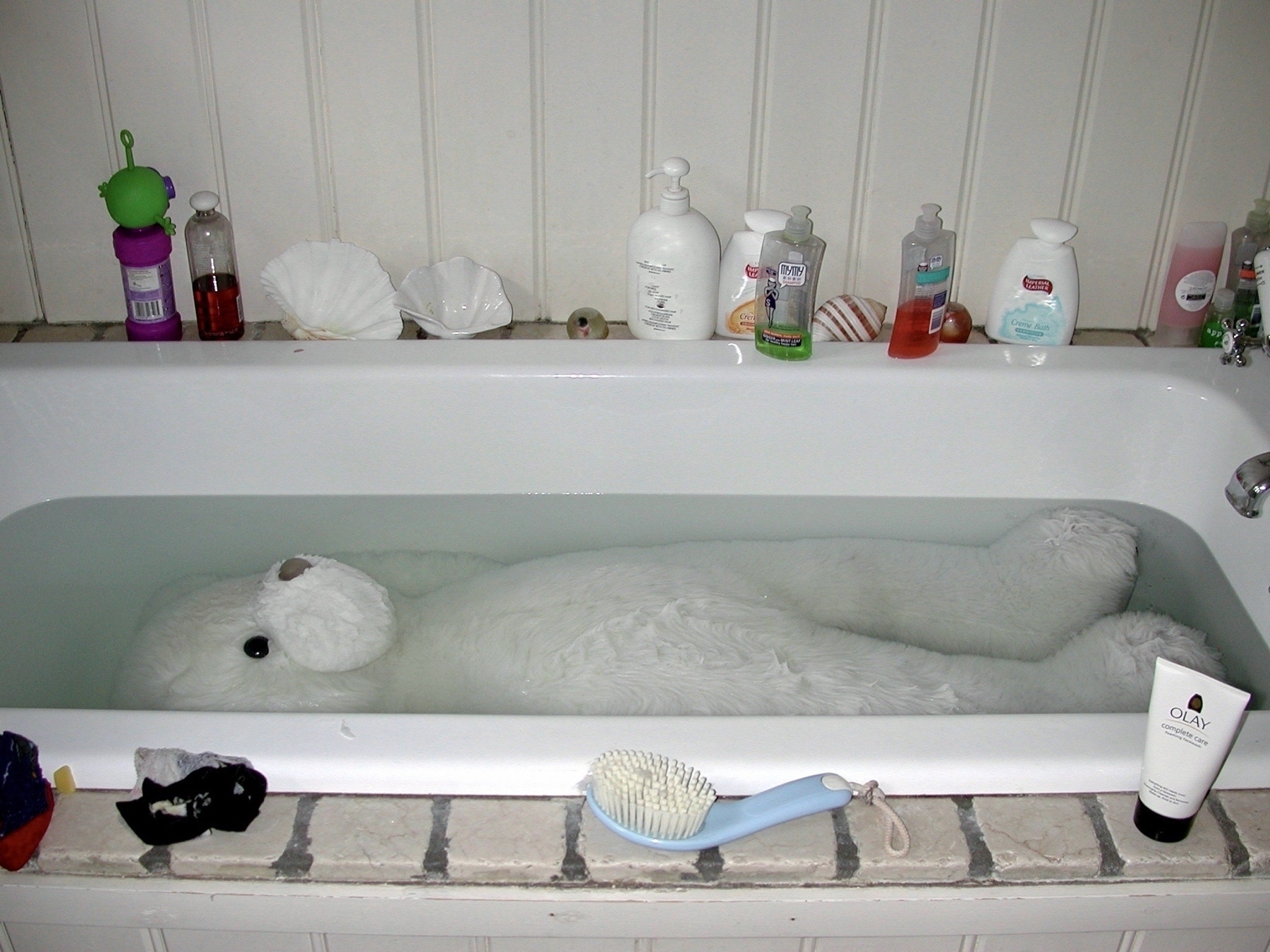 a large white bear in a bathtub. 