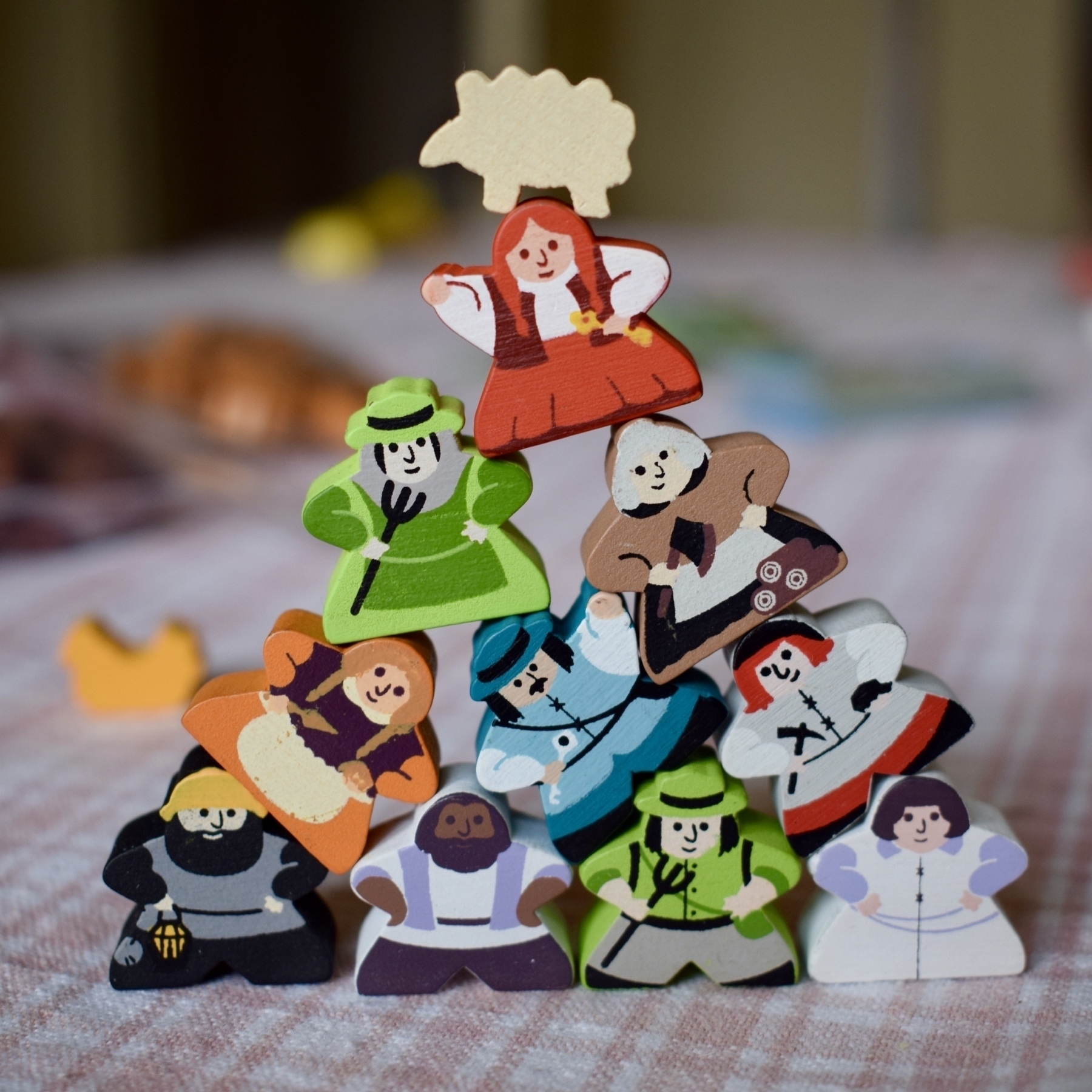 a stack of meeples with a sheep on top