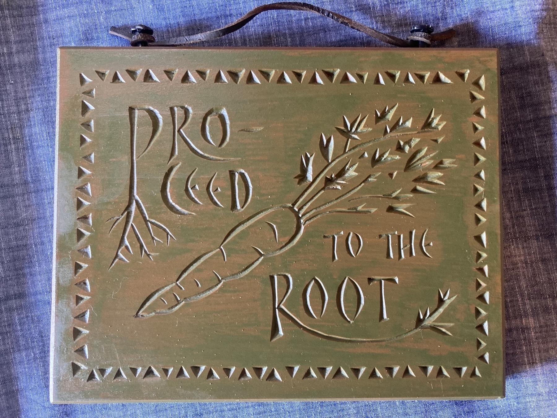 wood carving of carrot with legend proceed to the root