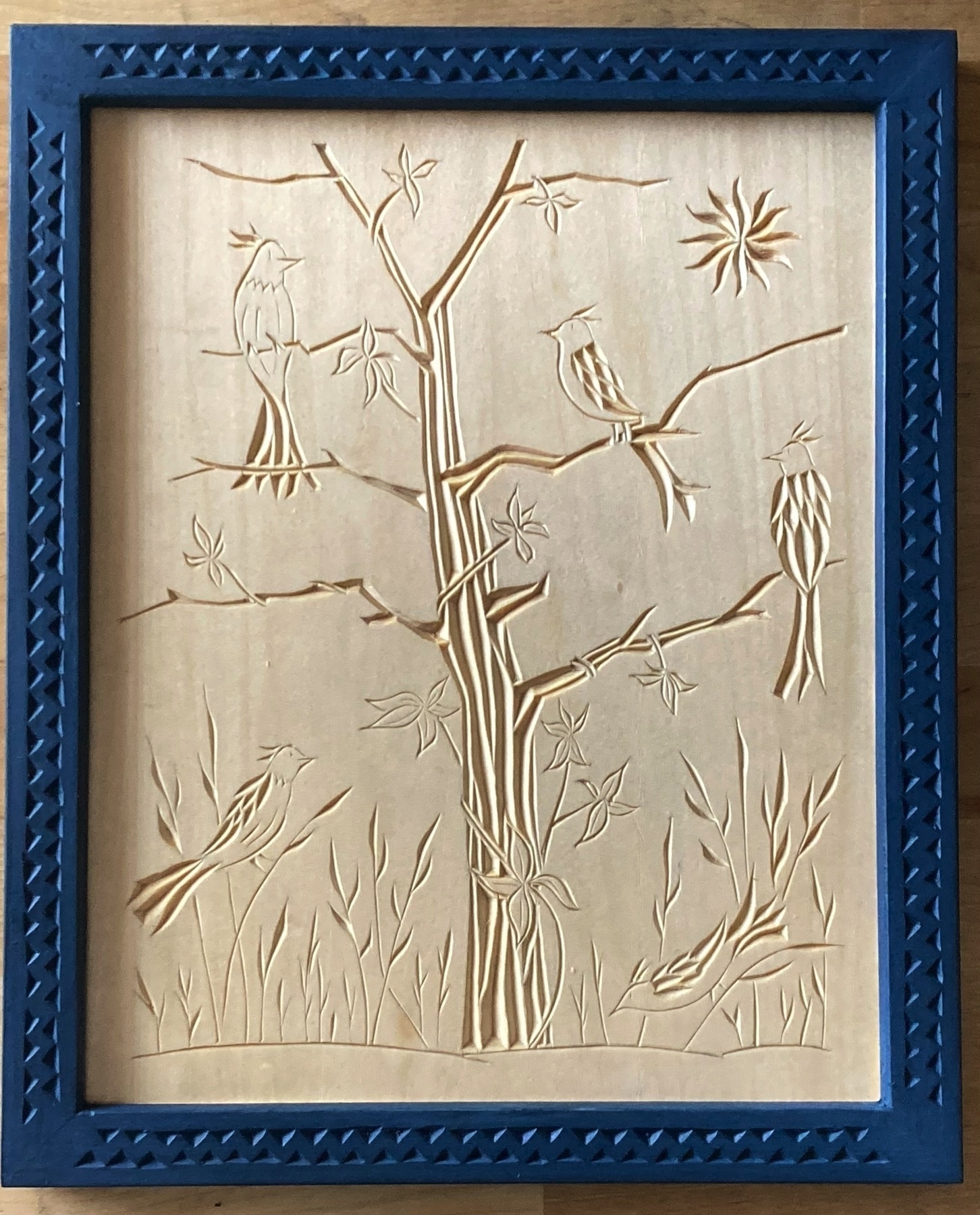 chip carving of a tree vined with Virginia creeper and five birds