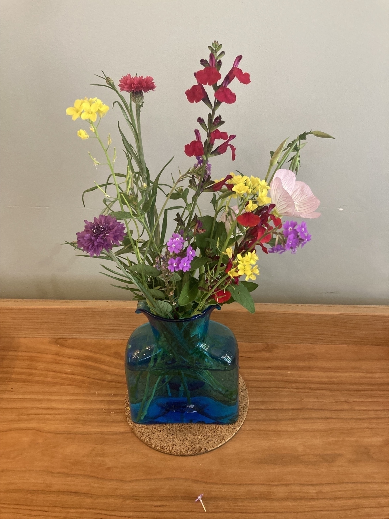posy of various color flowers in a blue vase