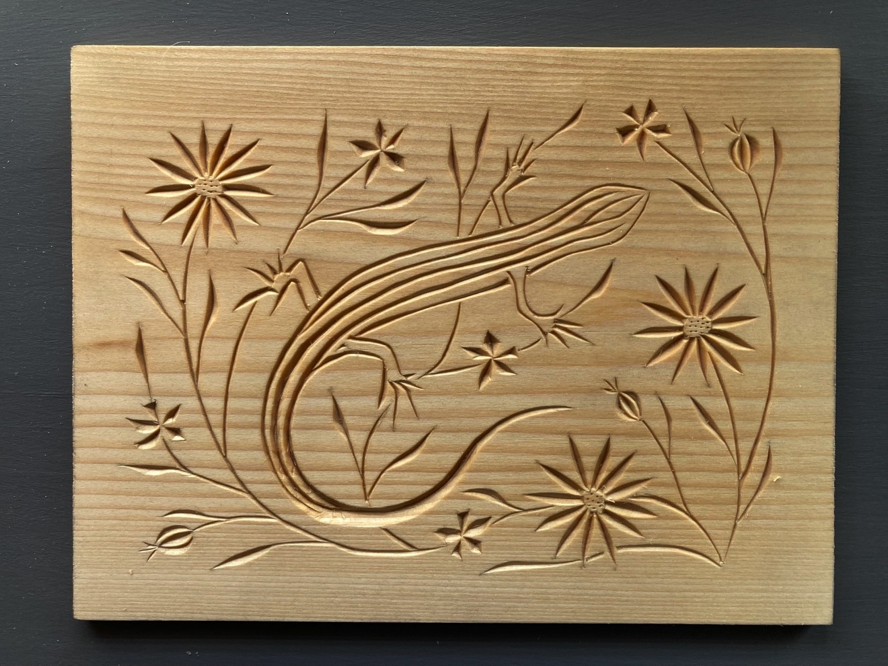 chip carving of five-lined skink with flowers