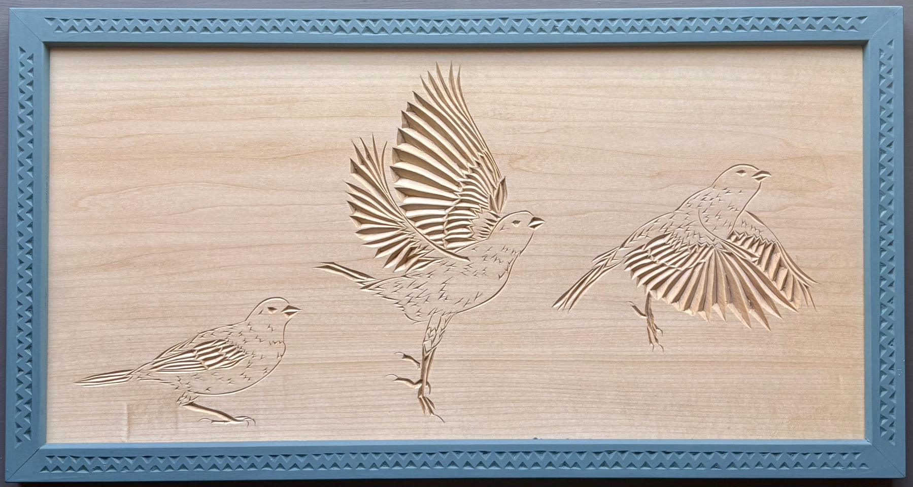 chip carving with three views of a finch taking flight