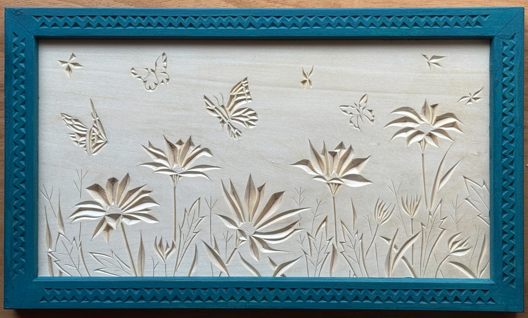 chip carving of butterflies and flowers, peacock-blue frame
