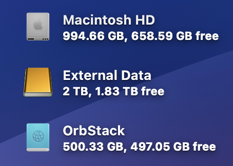 Three drive icons on the macOS 26.1 beta 1 desktop: Macintosh HD, External Data, and OrbStack. Macintosh HD and OrbStack have updated icons to fit the Tahoe look and feel, while the external data drive continues to display an icon from previous versions of macOS.
