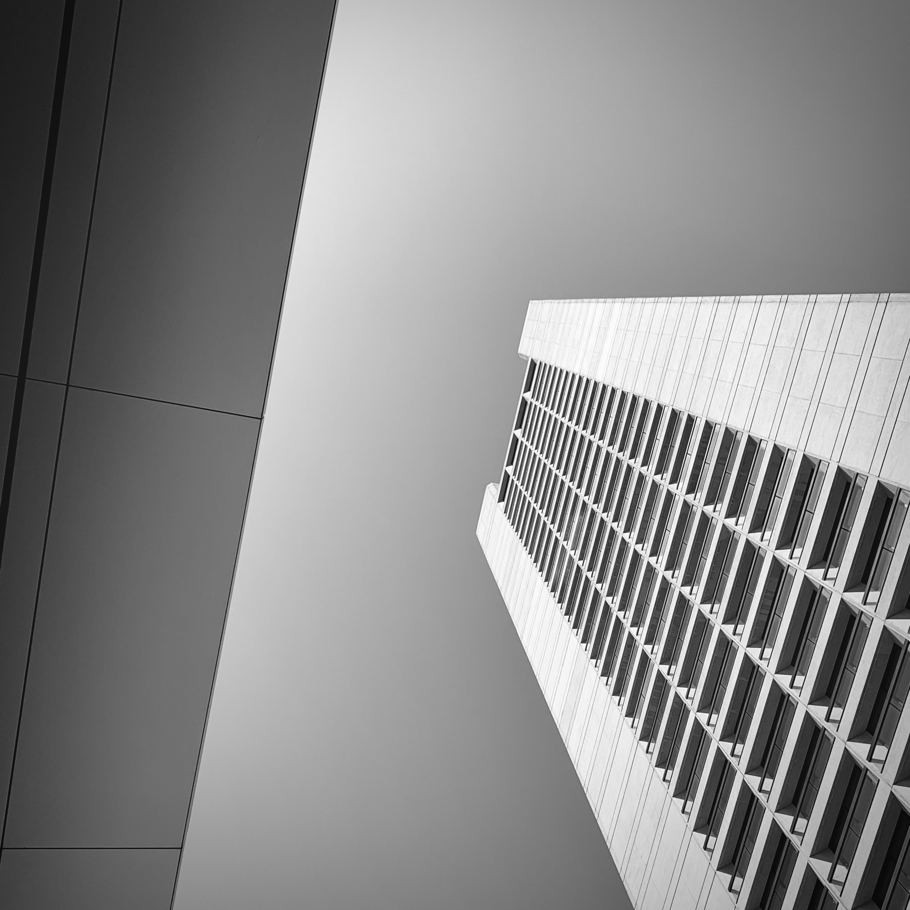 Looking upward at a large skyscraper, black and white.