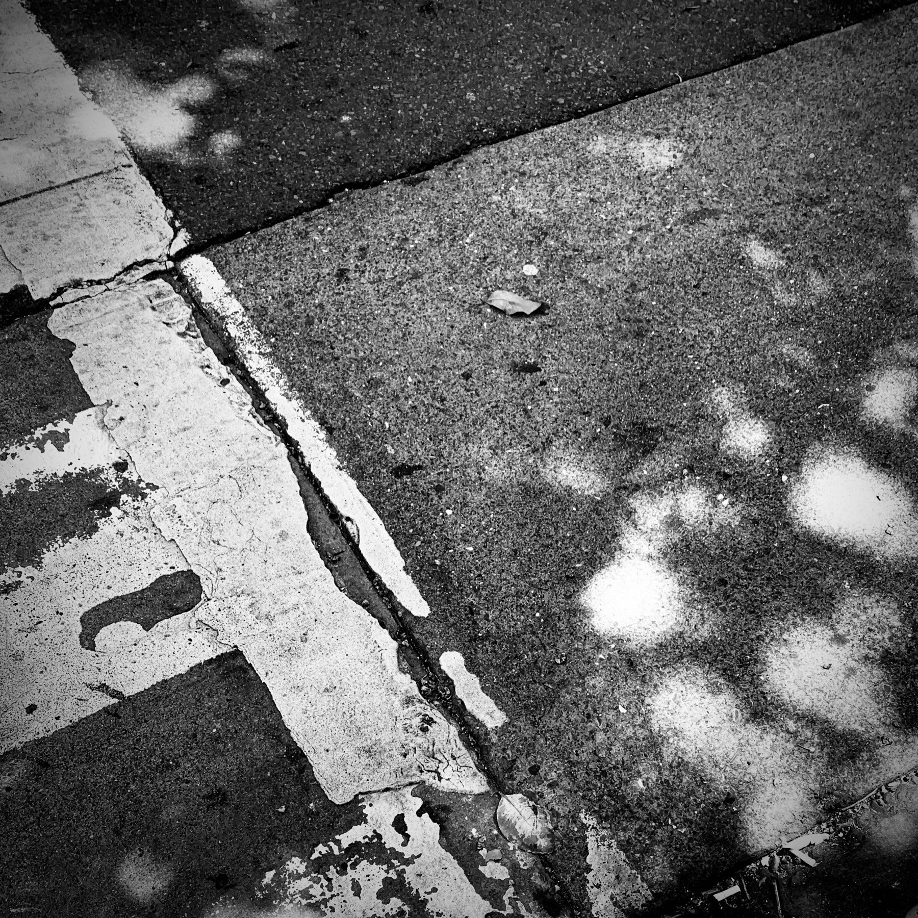 Painted, faded crosswalk lines on a city street. 