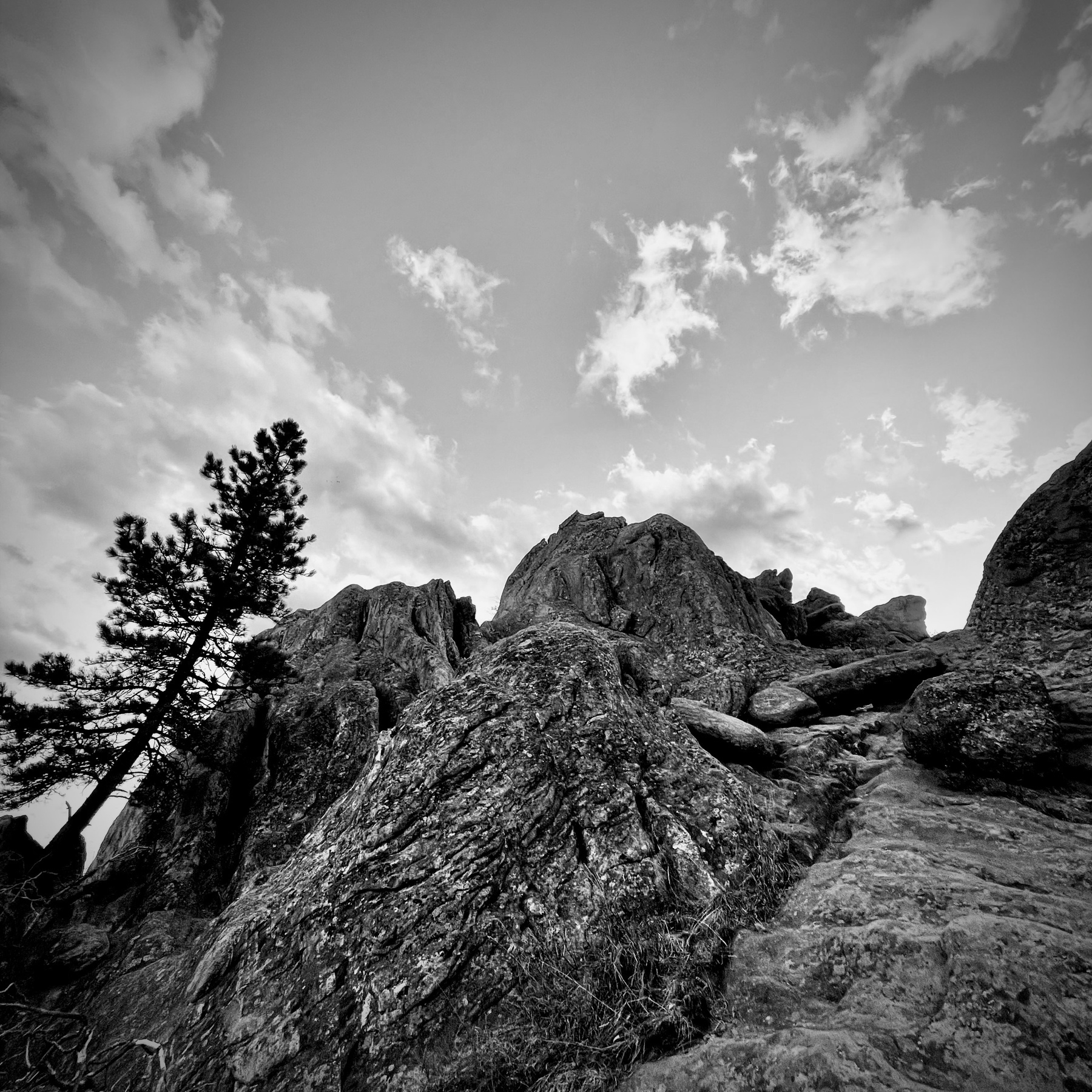 Black and white rock formations with lightly clouded sky. 