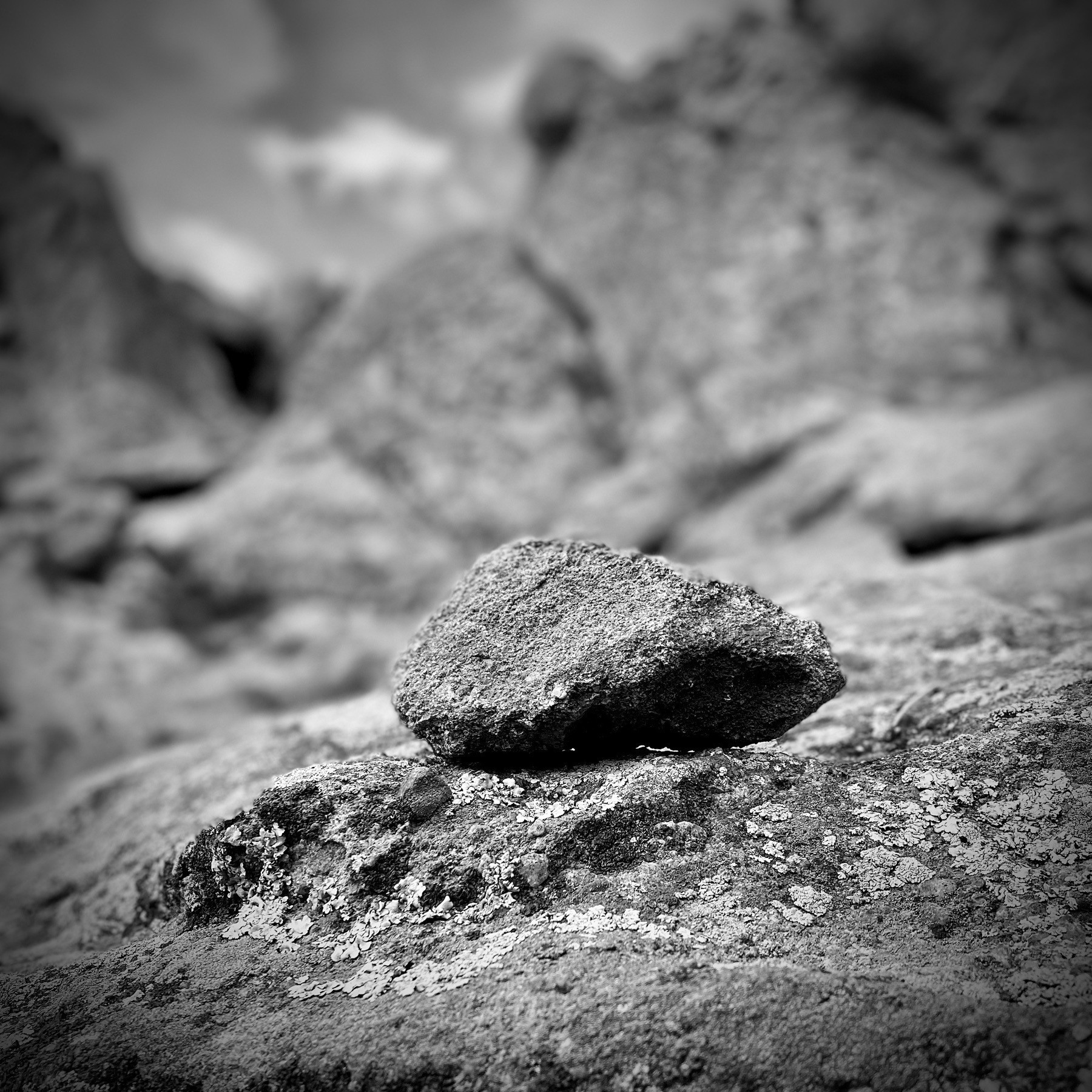 Stone atop boulders, black and white.