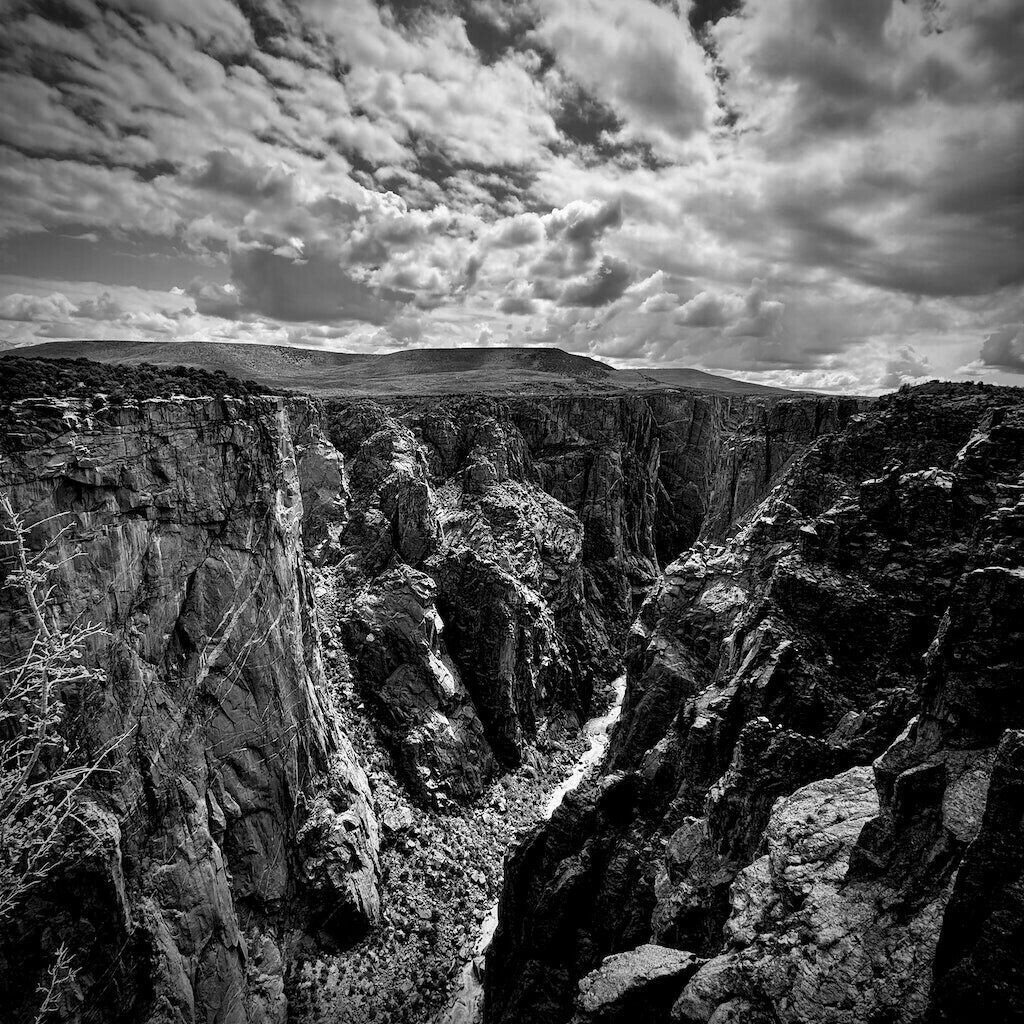  Clouded sky over large canyon. Black and white. 