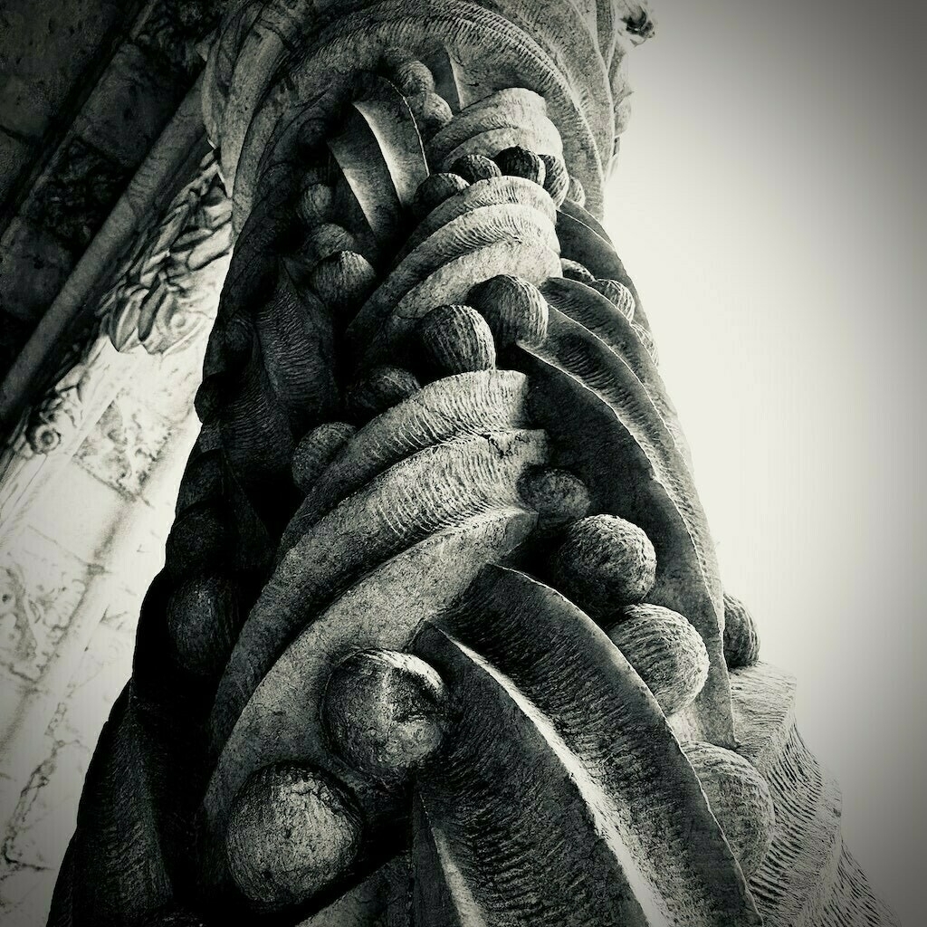 Ornate stone column, black and white. 