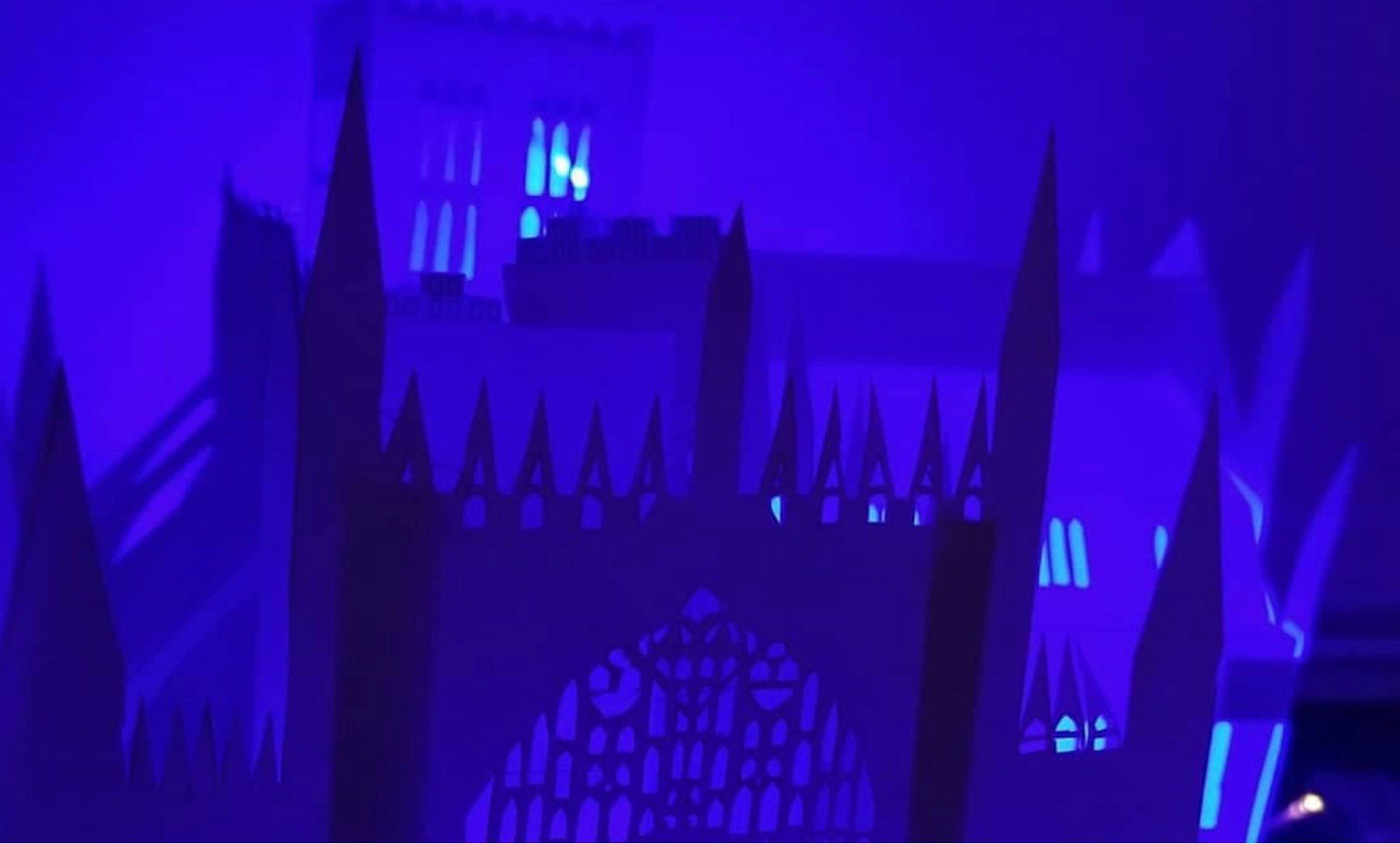 An image of a paper model of York Minster at night in a purple glow. 
