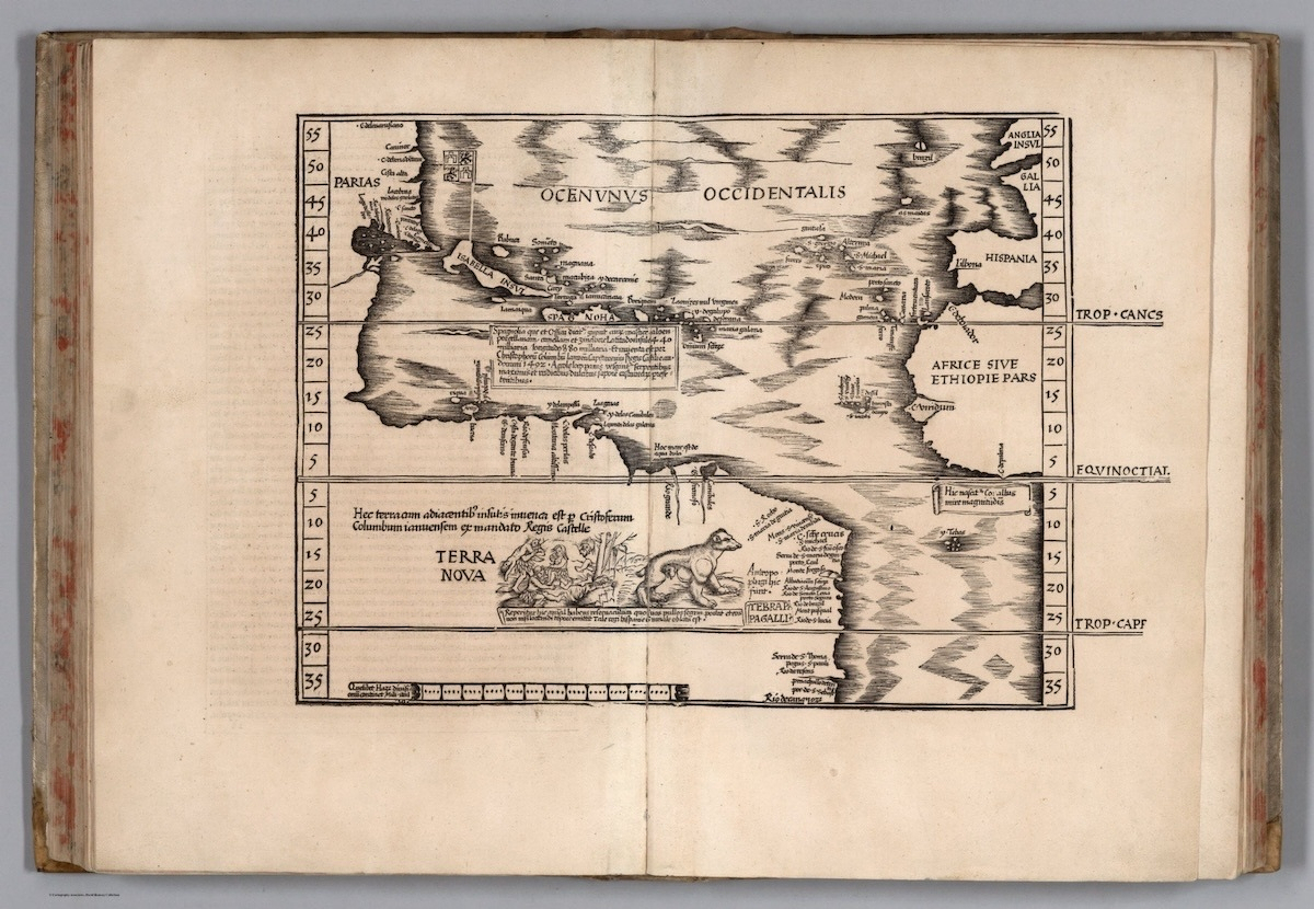 An old book is open to a map showing the Atlantic Ocean as it was conceived in the sixteenth century