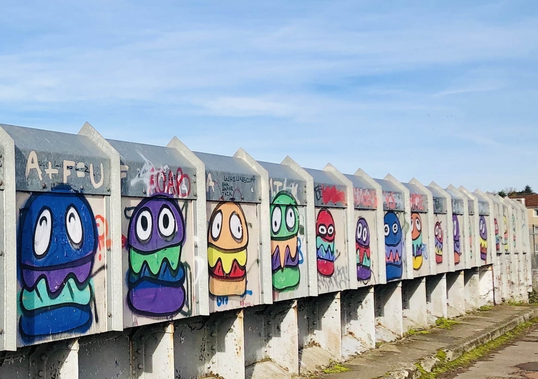 Colourful graffiti of burgers on a bridge