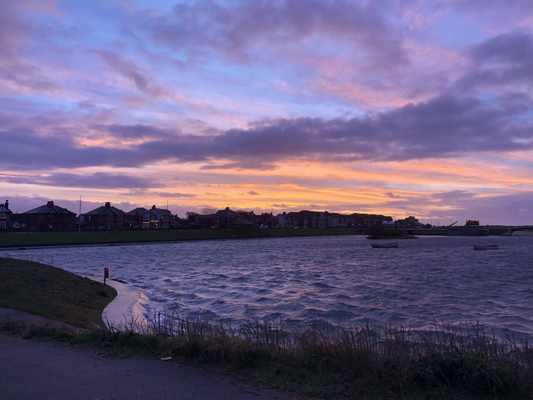Purple and orange sunset sky over a choppy lake