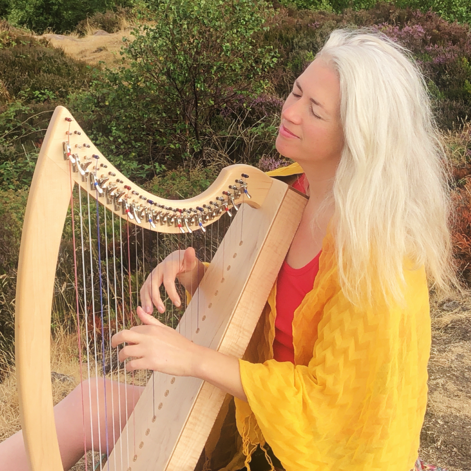 girl with silver hair playing the harp in nature