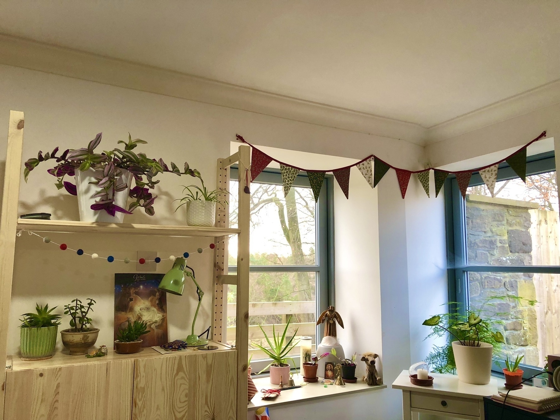 corner of room featuring two windows with bunting hung across them