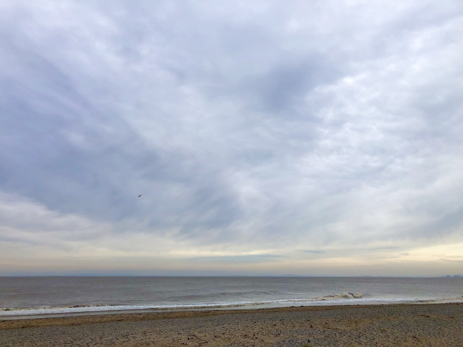Beach scene with pastel light and soft grey clouds