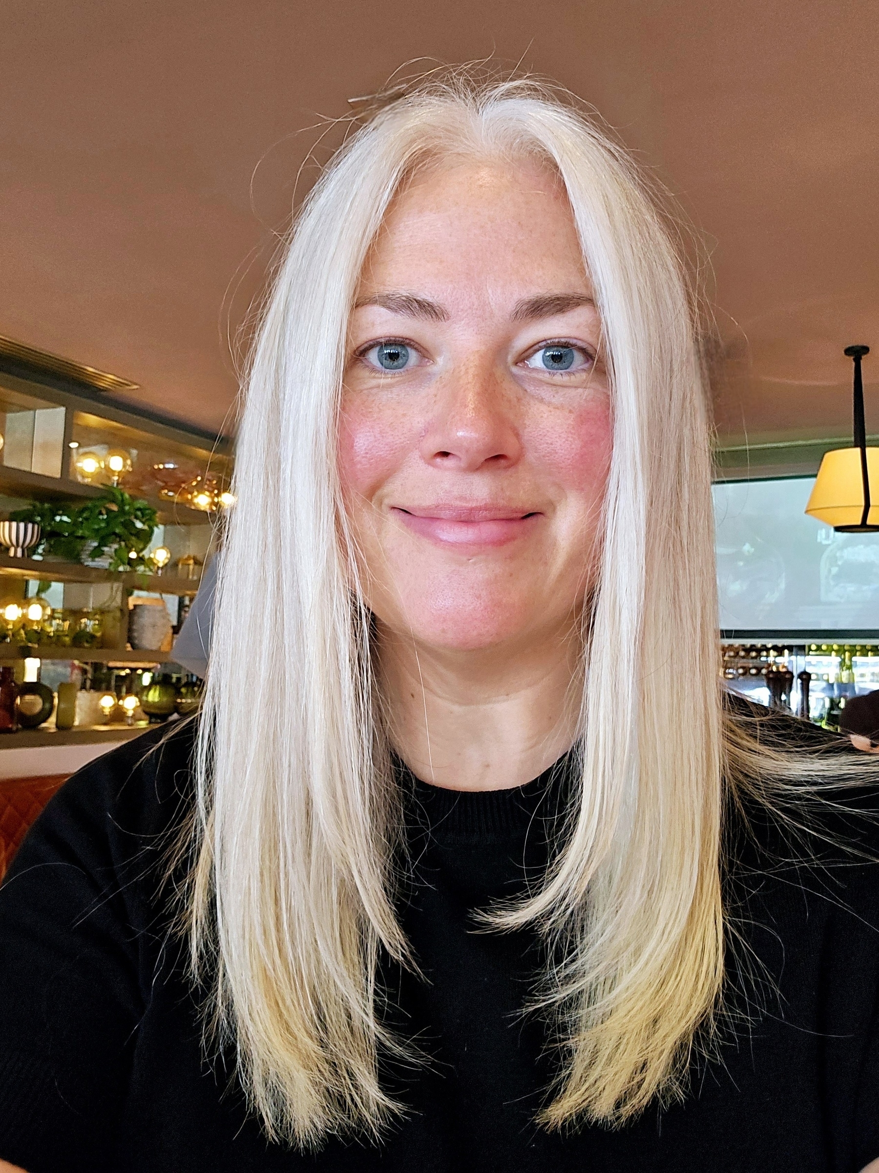 Woman with long white hair smiling at the camera