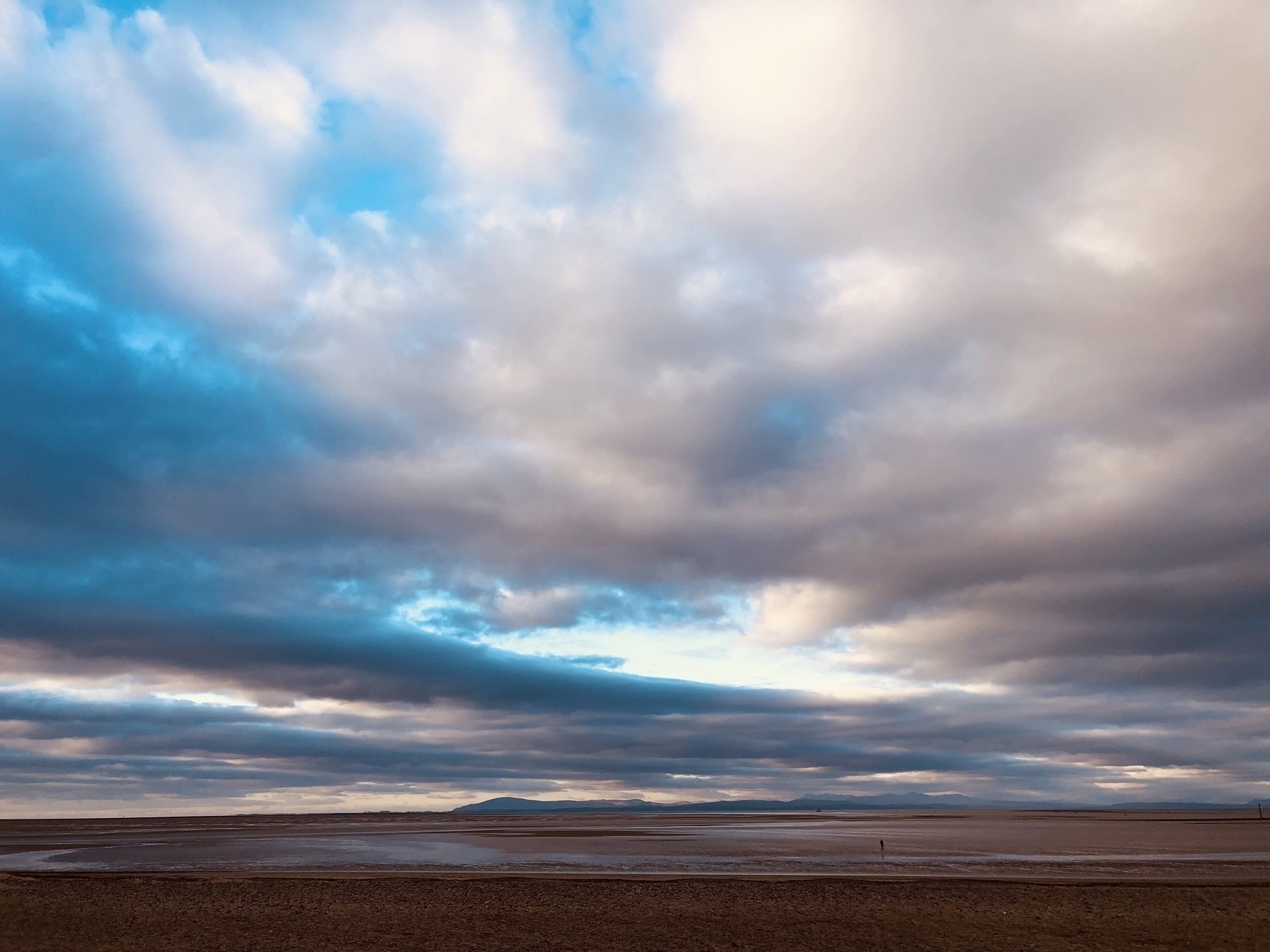 A cloudy sky in Lancashire at low tide in an estuary 