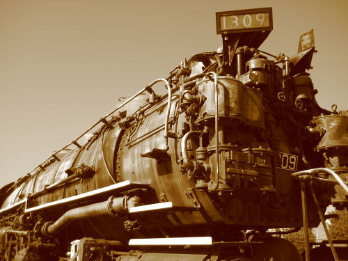Sepia tone. A large, menacing locomotive seen from a low angle.
