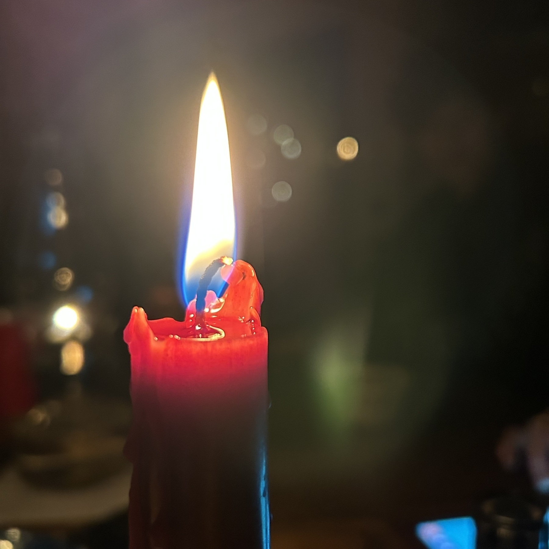 The glowing flame of a red candle.