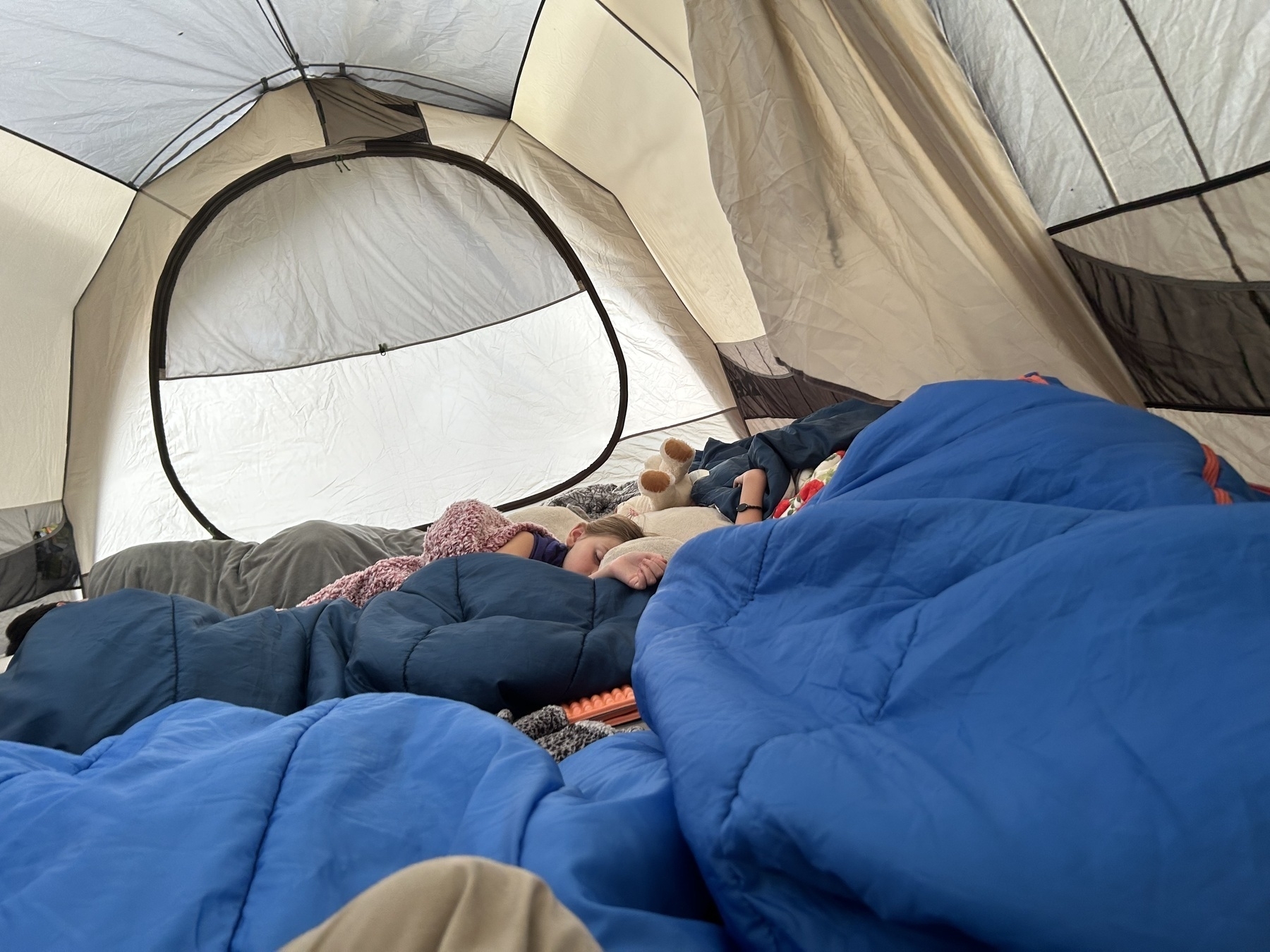 family in sleeping bags in a tent
