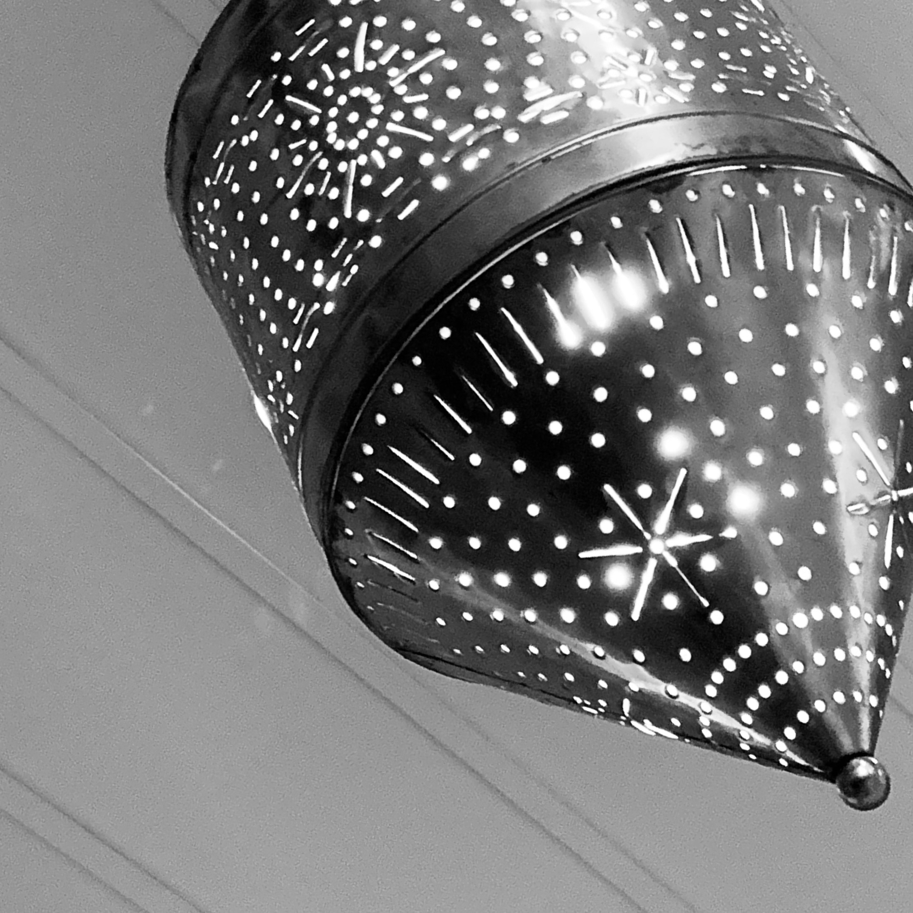 A metal lantern with holes, framed in a way that makes it look like a mole. The lantern is creating lots of interesting points of light through the holes. ￼