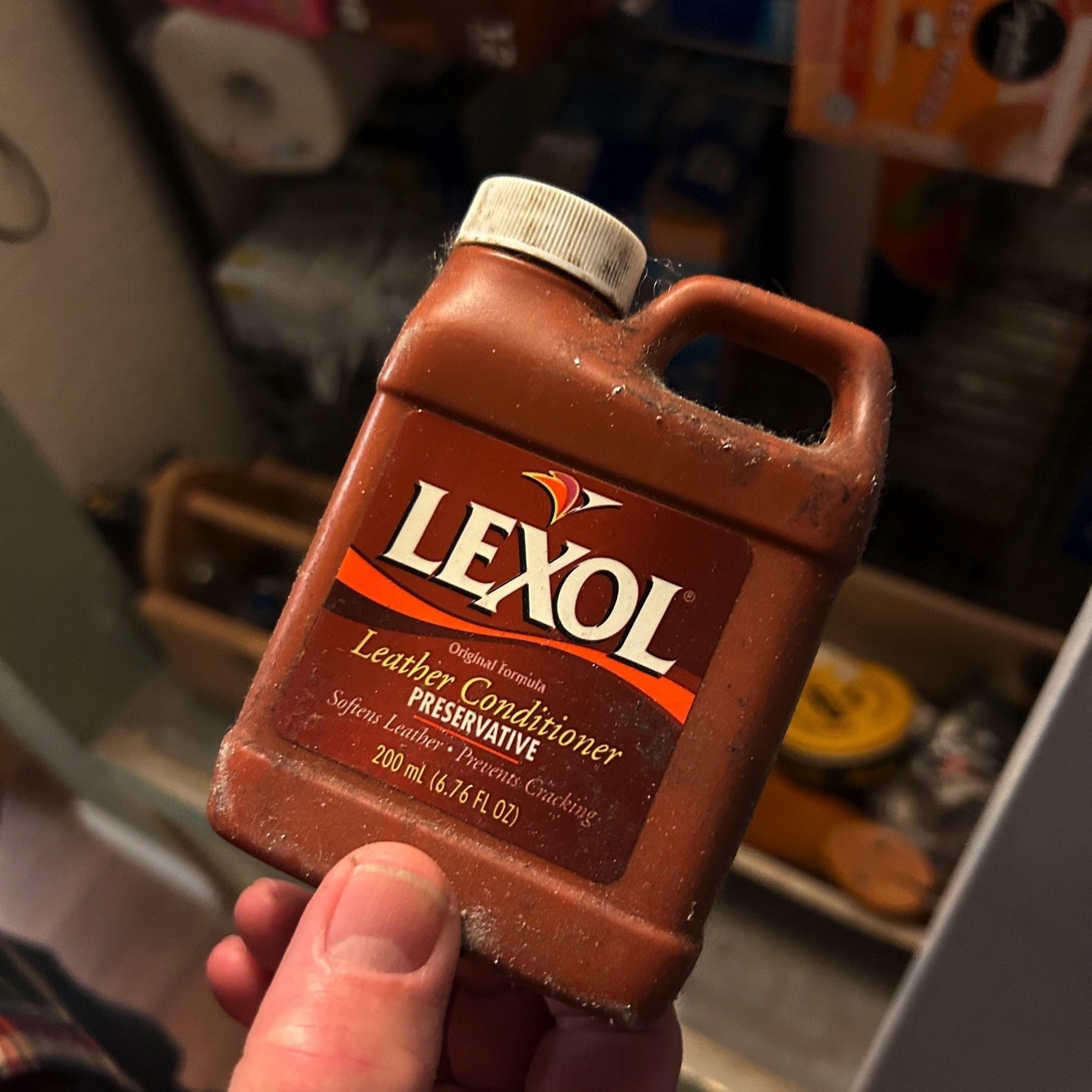 A small container of Lexol brand leather condition. The container reads: “Preservative” “Softens Leather • Prevents Cracking”