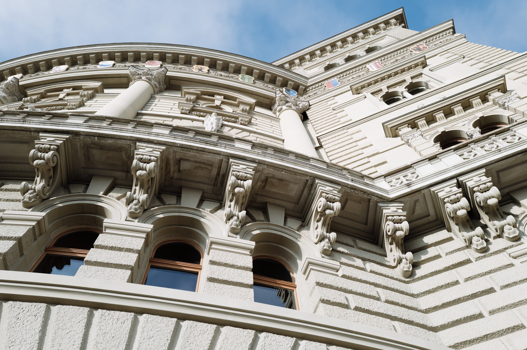 Looking up at the souther frontage of the Swiss parliament building in Bern. The photographer stood almost directly in front of the building creating a look of a towering building. 