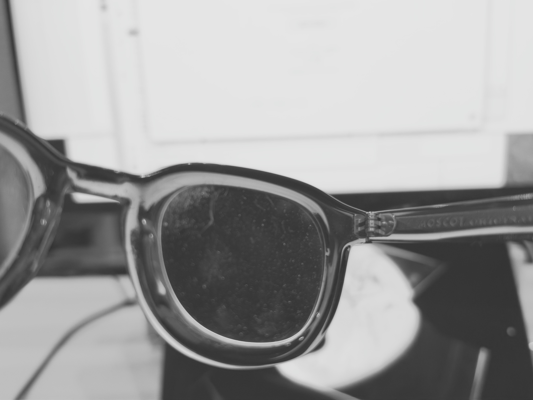 Auto-generated description: A close-up of a pair of eyeglasses resting on a surface with a blurred background.