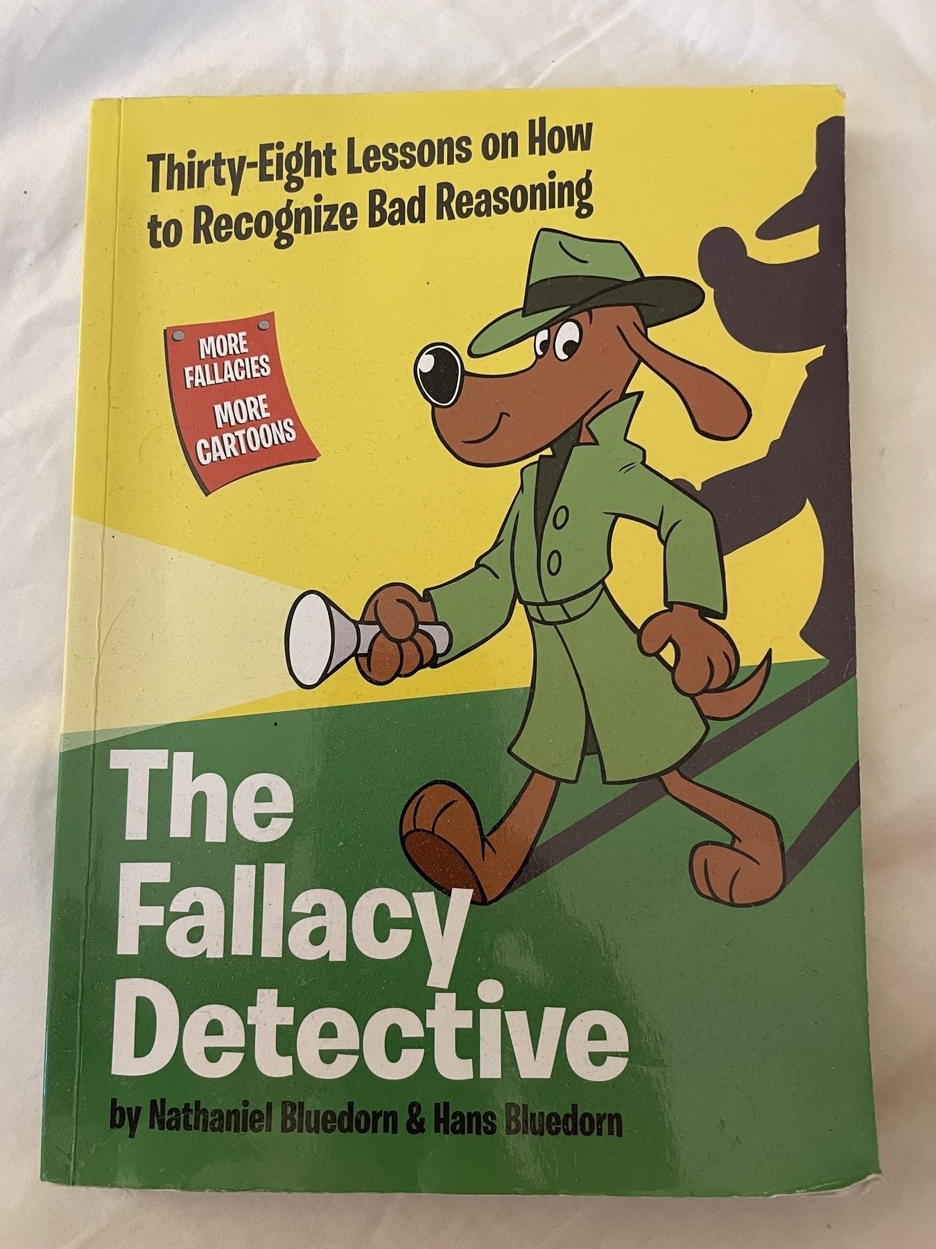 The cover of Nathaniel Bluedorn and Hans Bluedorn’s book for children, with a dog as private eye on the cover, called The Fallacy Detective: 38 Lessons on how to recognize bad reasoning.