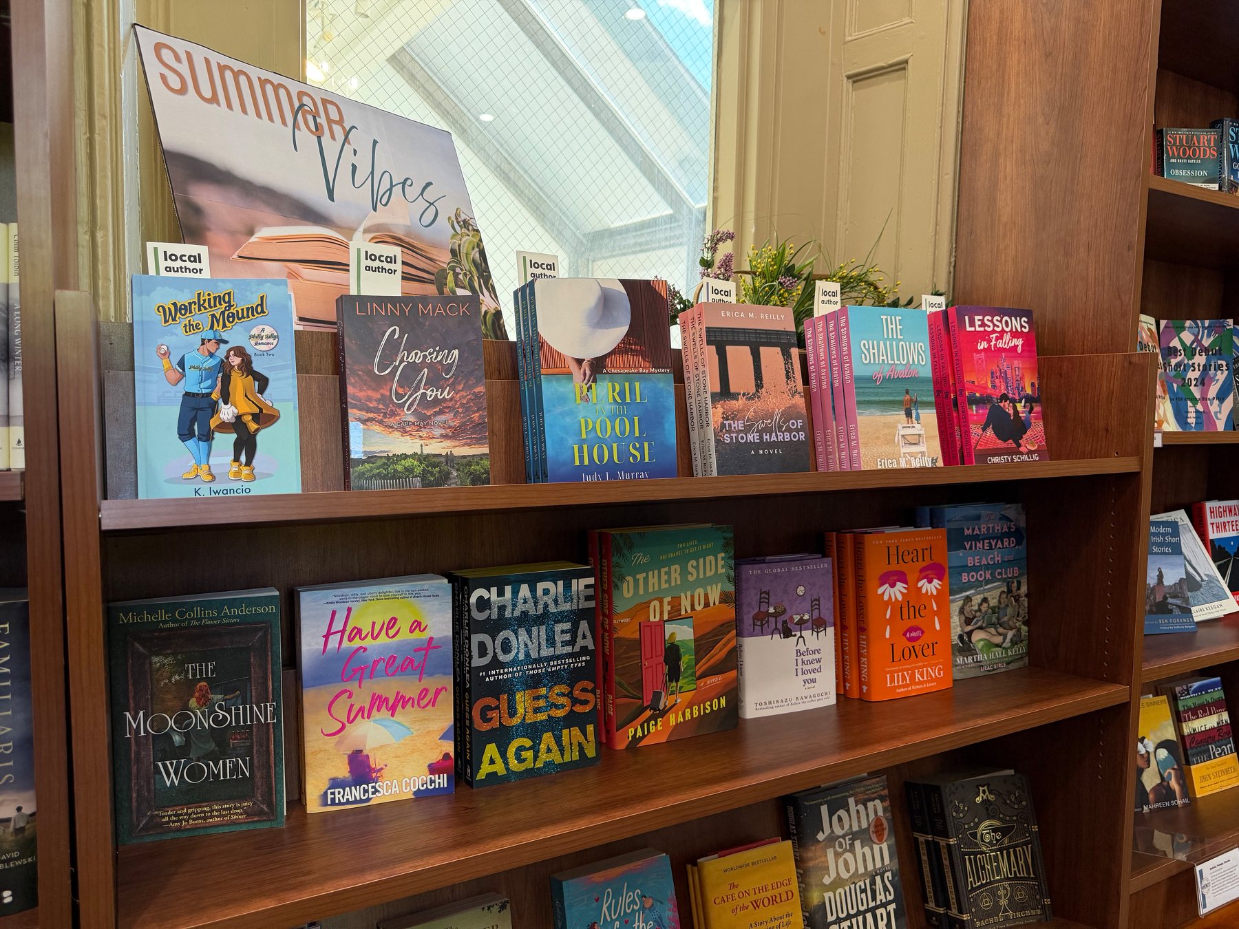 A bookshelf displays a collection of colorful books, including titles in the Summer Vibes section.