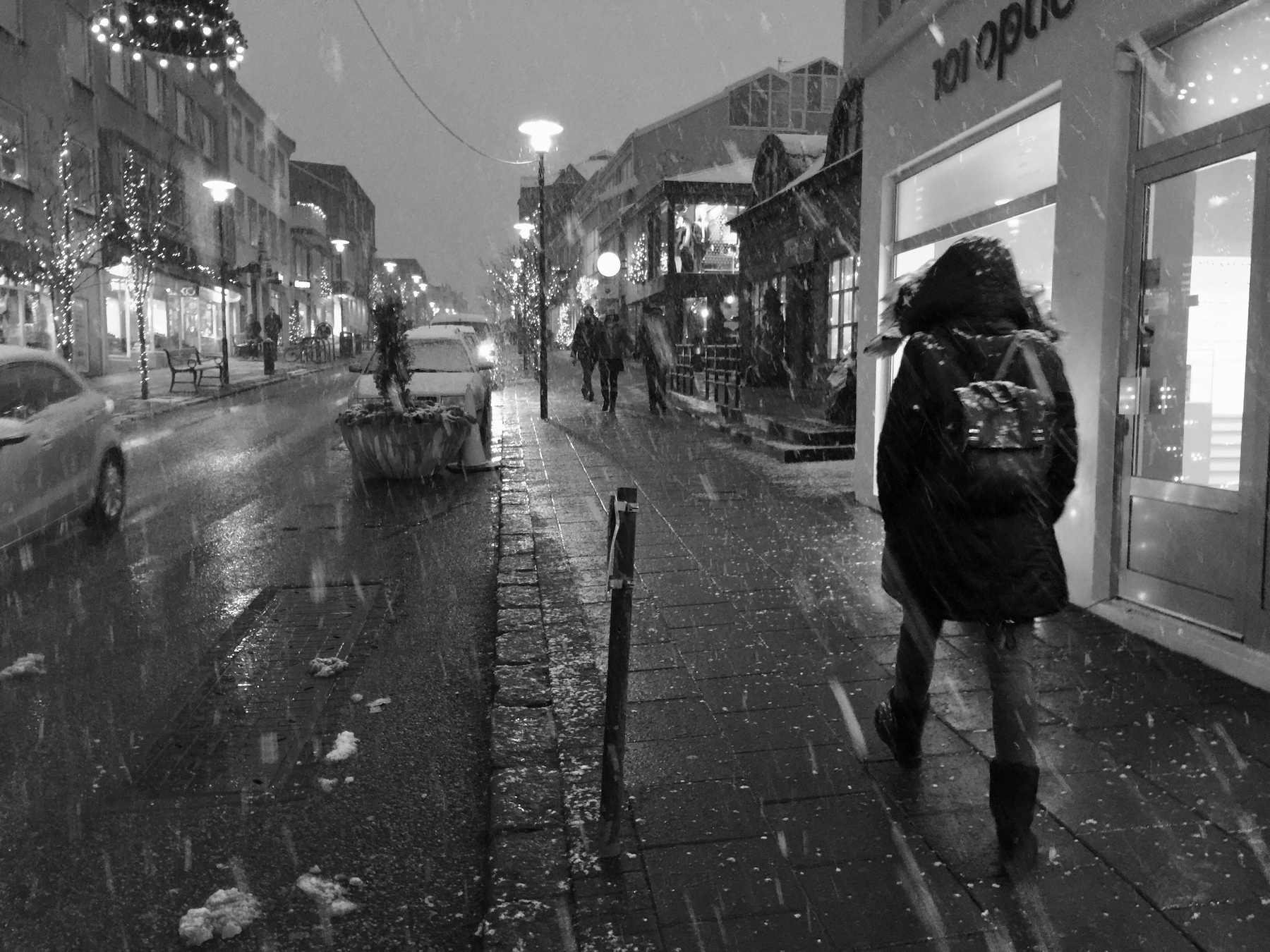 People walking in Reykjavík city centre while it’s snowing.