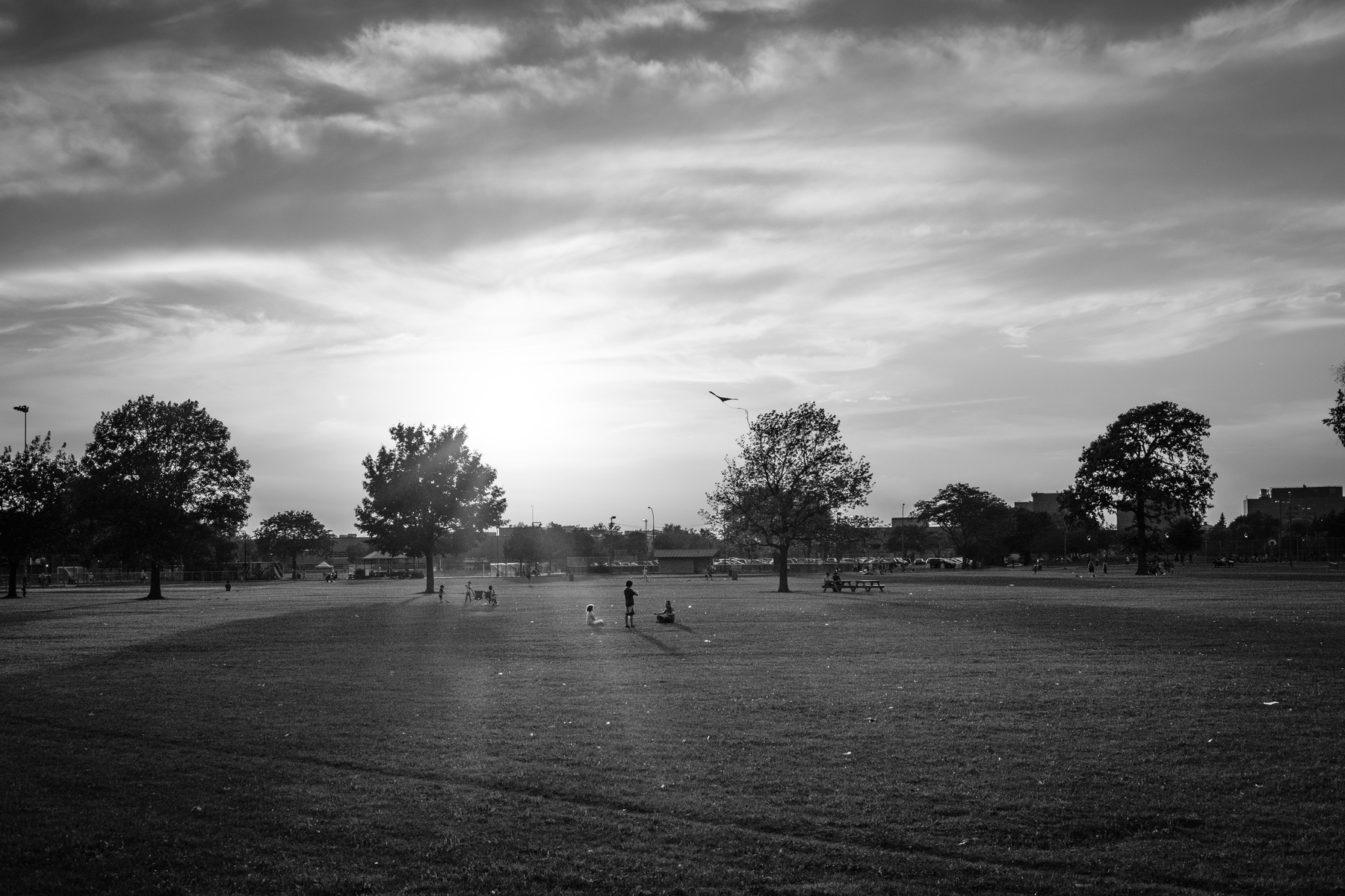 Children fly a kit in Parc Jarry, in black and white.