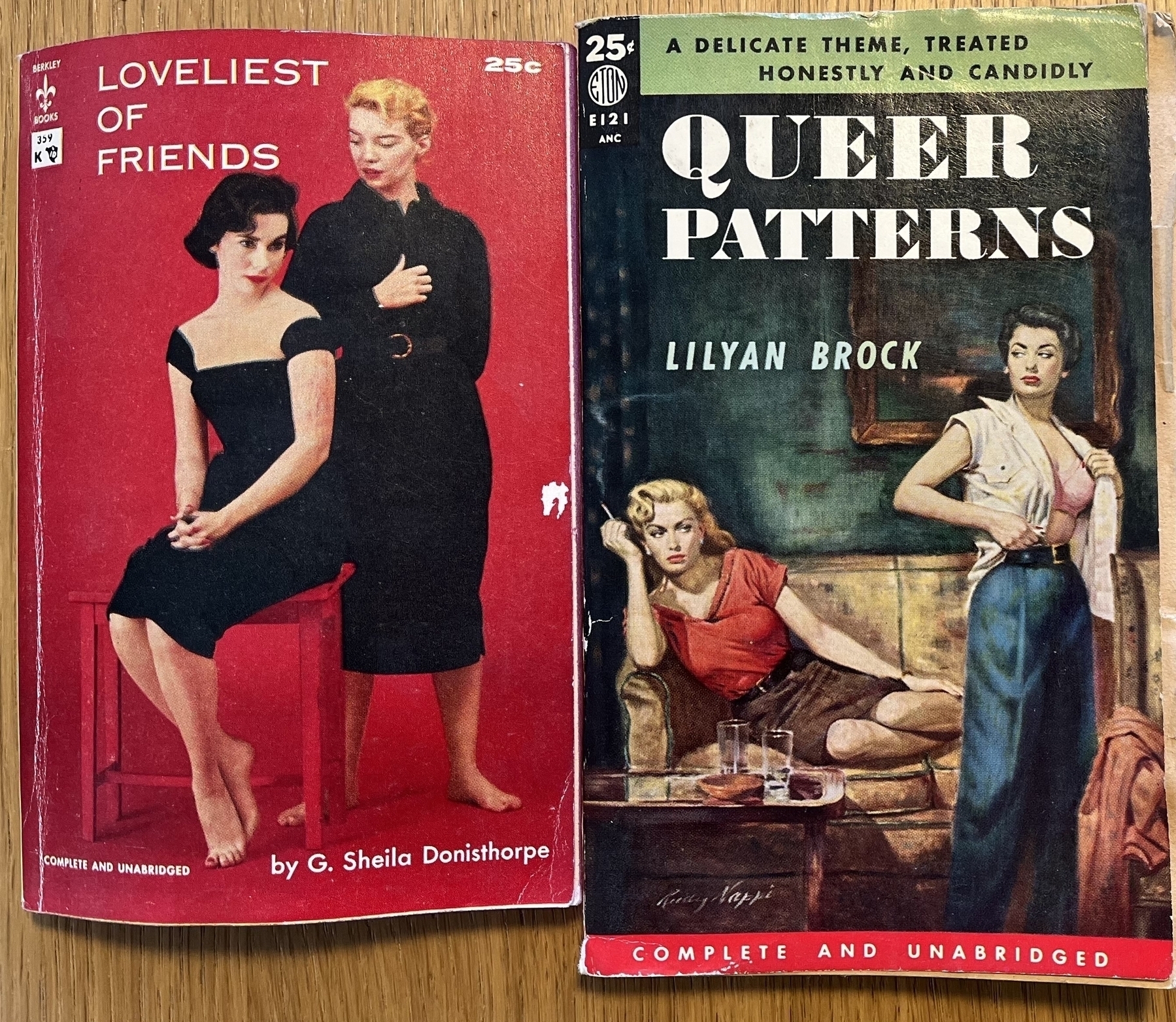 Two old pulp paperbacks. The first is titled “The Loveliest of Friends: complete and unabridged” by G. Sheila Donisthorpe and features a pair of women that probably don’t have a platonic relationship. The second is titled “Queer Patterns: a delicate theme treated honestly and candidly” by Lilyan Brock. Again “complete and unabridged”. It features two women. One is lounging on the sofa, smoking.
