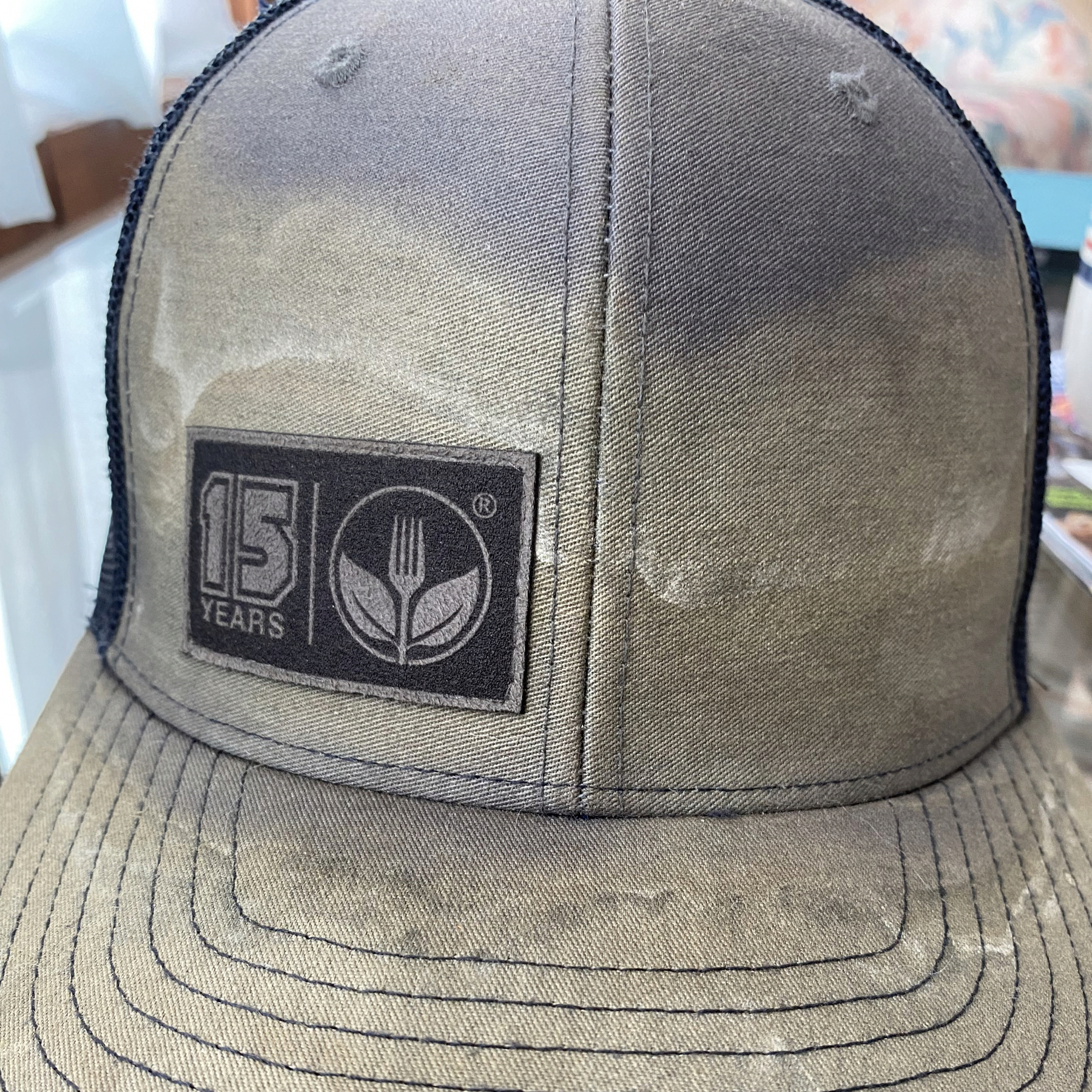 Sweat stained gray and black trucker hat with a 15 years Agrian logo.