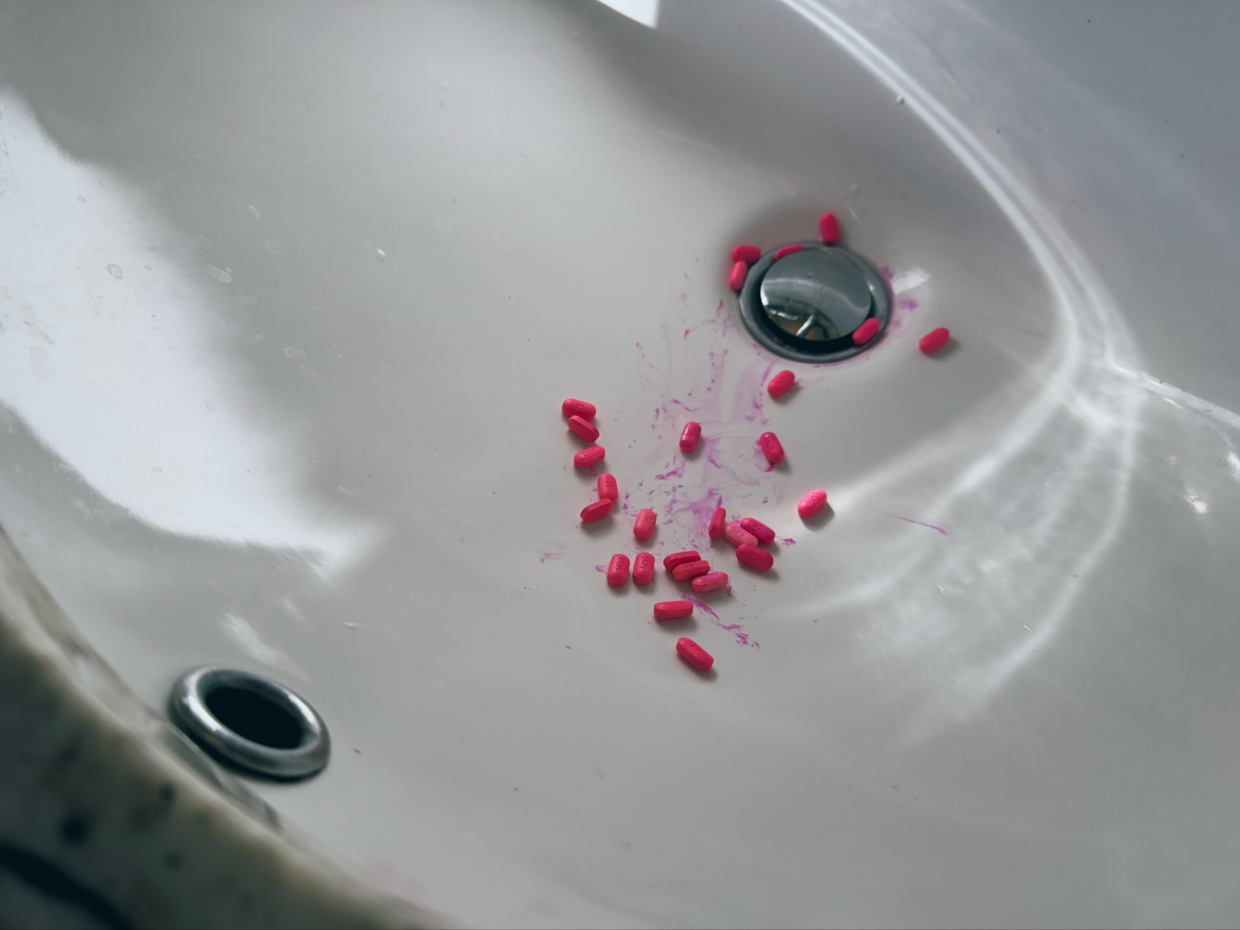 I spilled a bunch of tiny pink Benadryl pills into a wet sink. Lots of pink streaks in the sink from me trying to scoop up the slippery guys. 