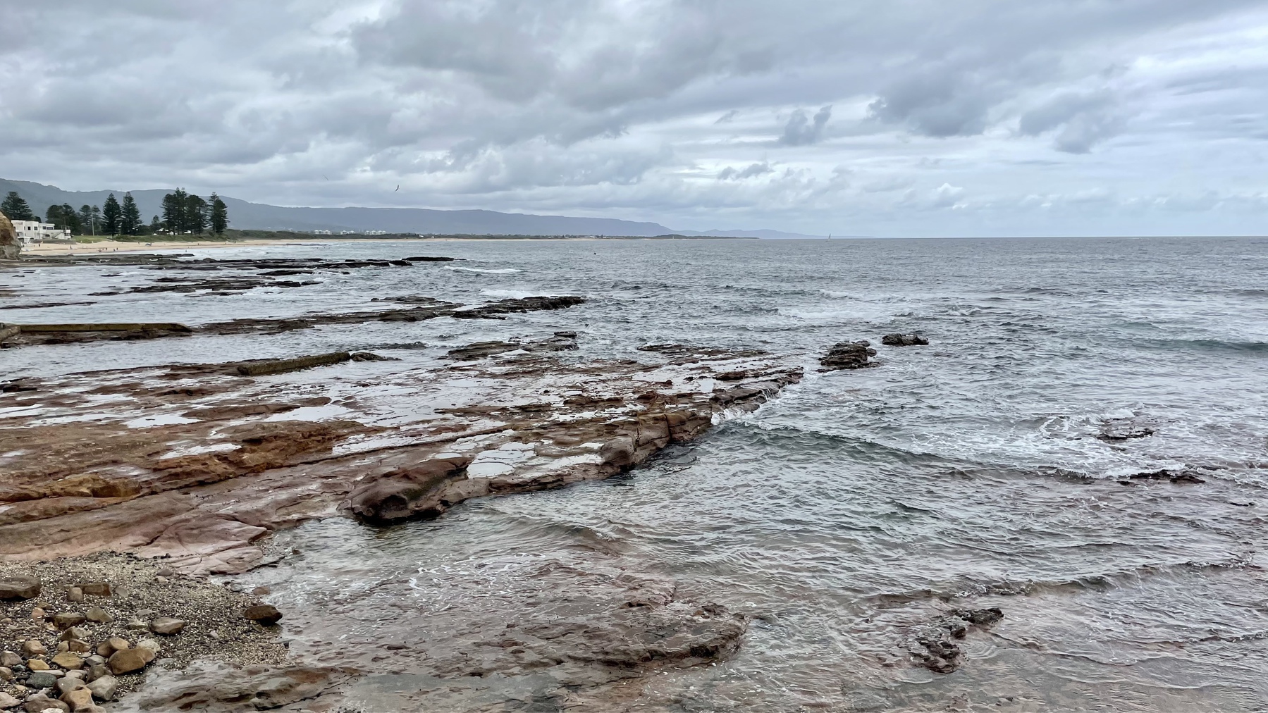 Rockpools in the foreground and beaches and the mountain escarpment stretching into the distance