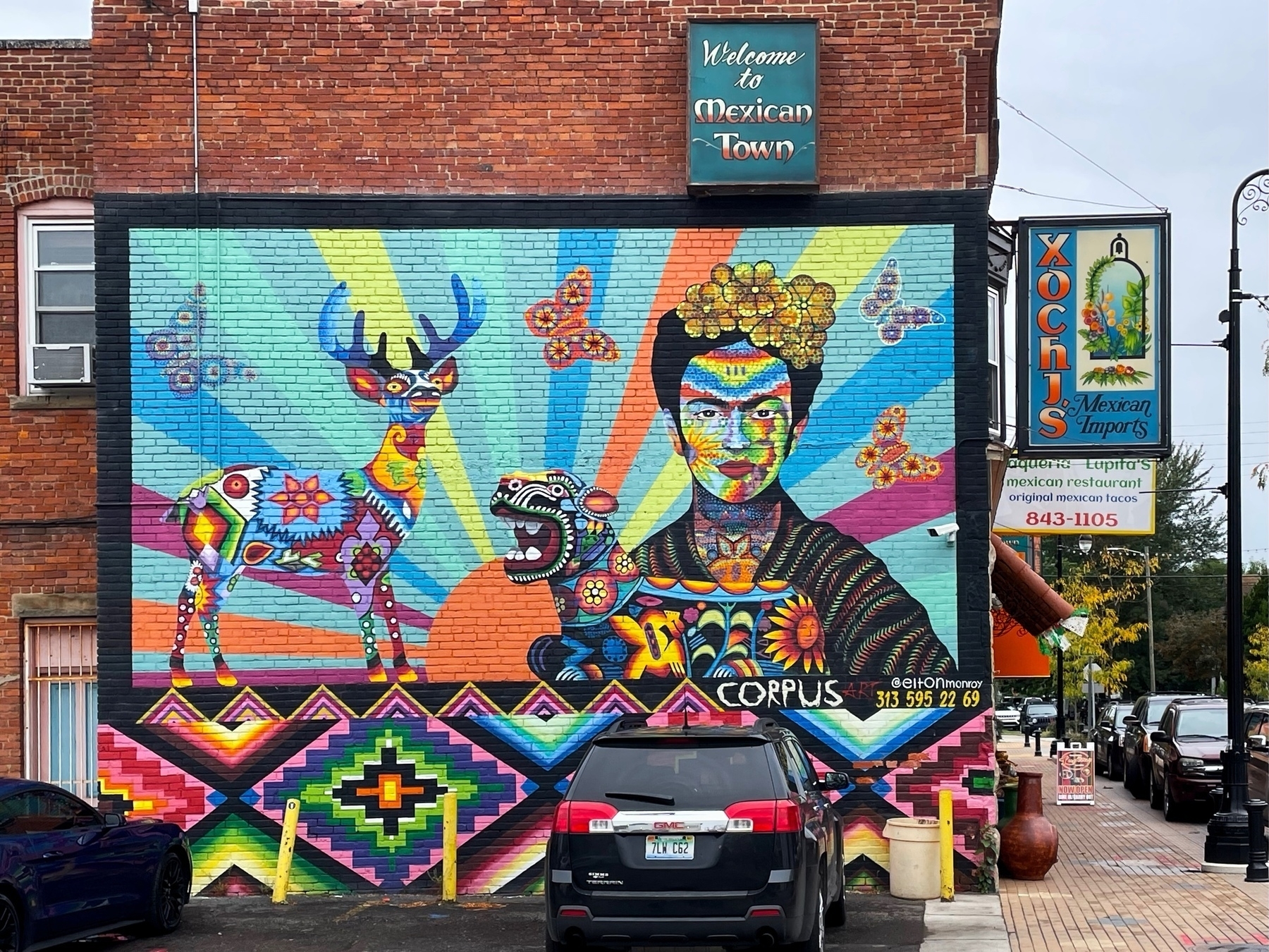 colorful wall mural of Frida Kahlo on the side of a brick building