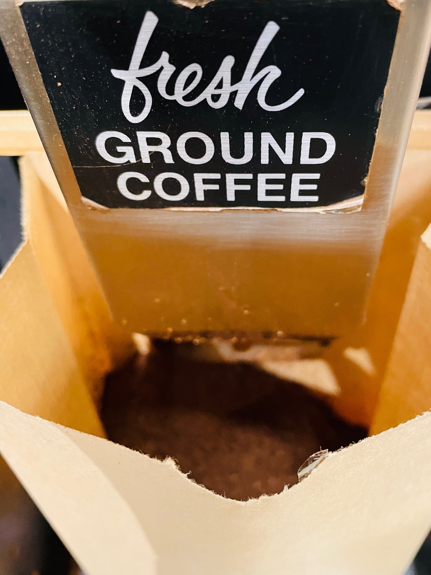 coffee being ground into a paper bag