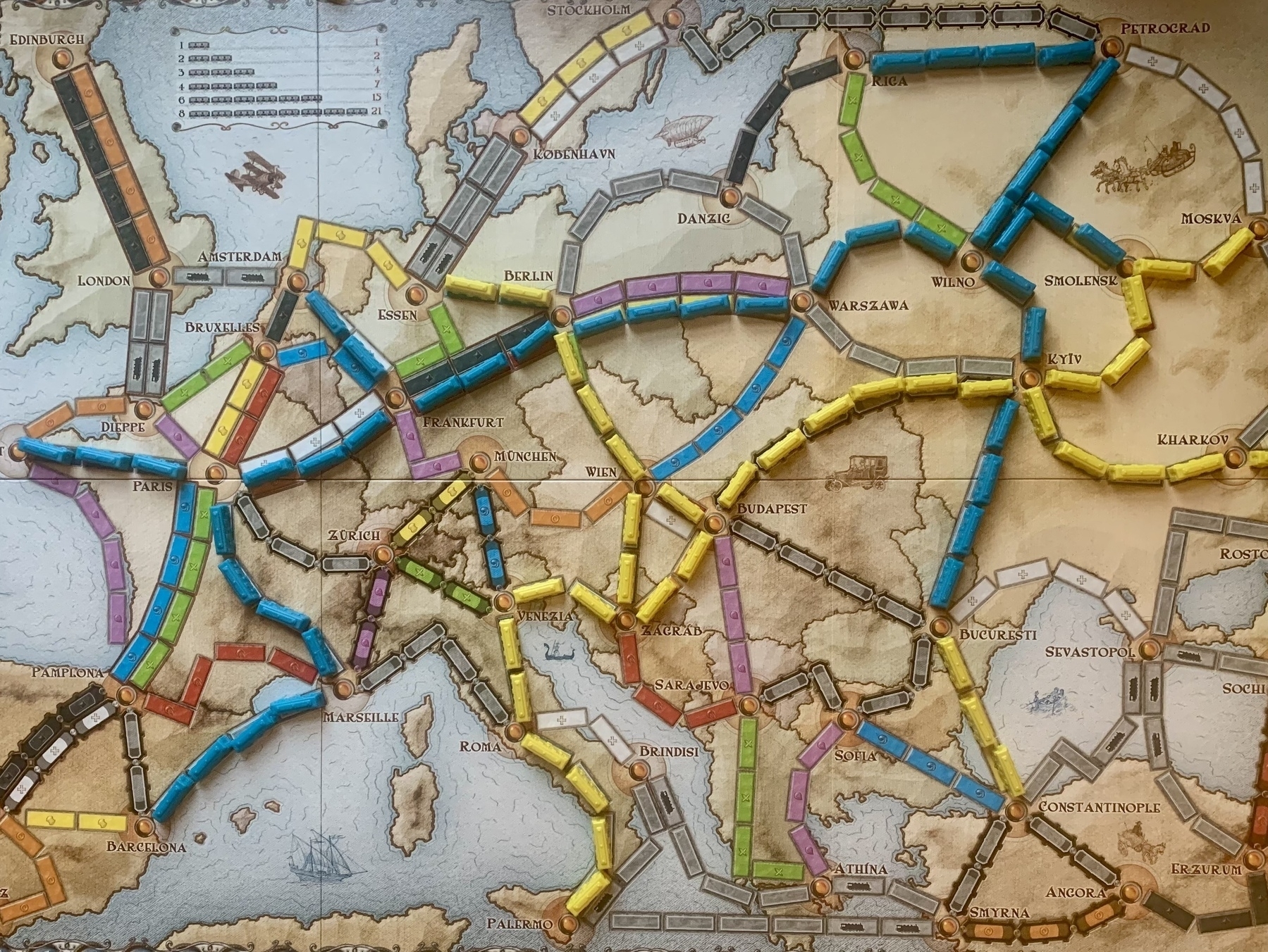 Ticket to Ride Europe game board with yellow and blue plastic train carriages making routes.