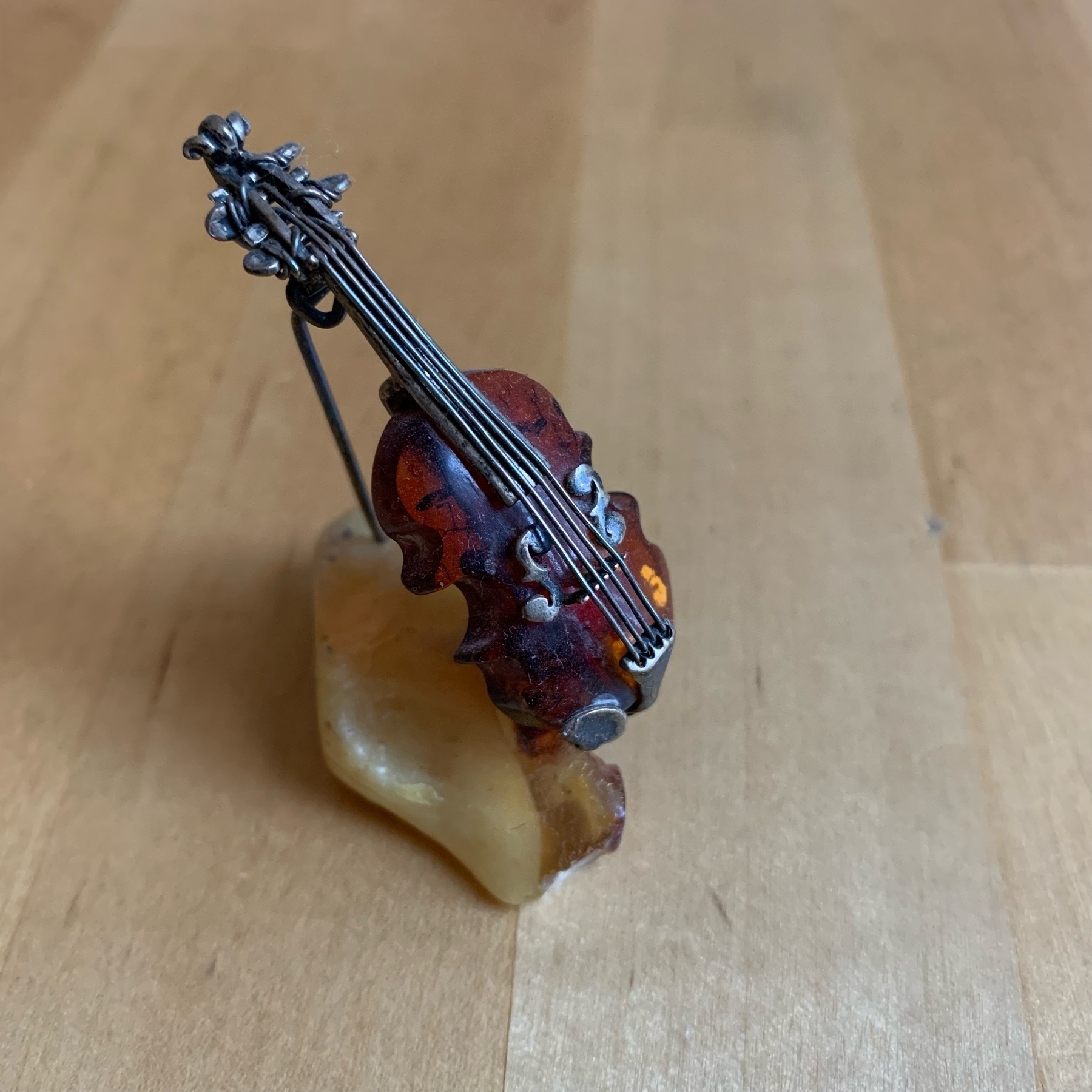 Minature cello on a stand made of amber resin and iron