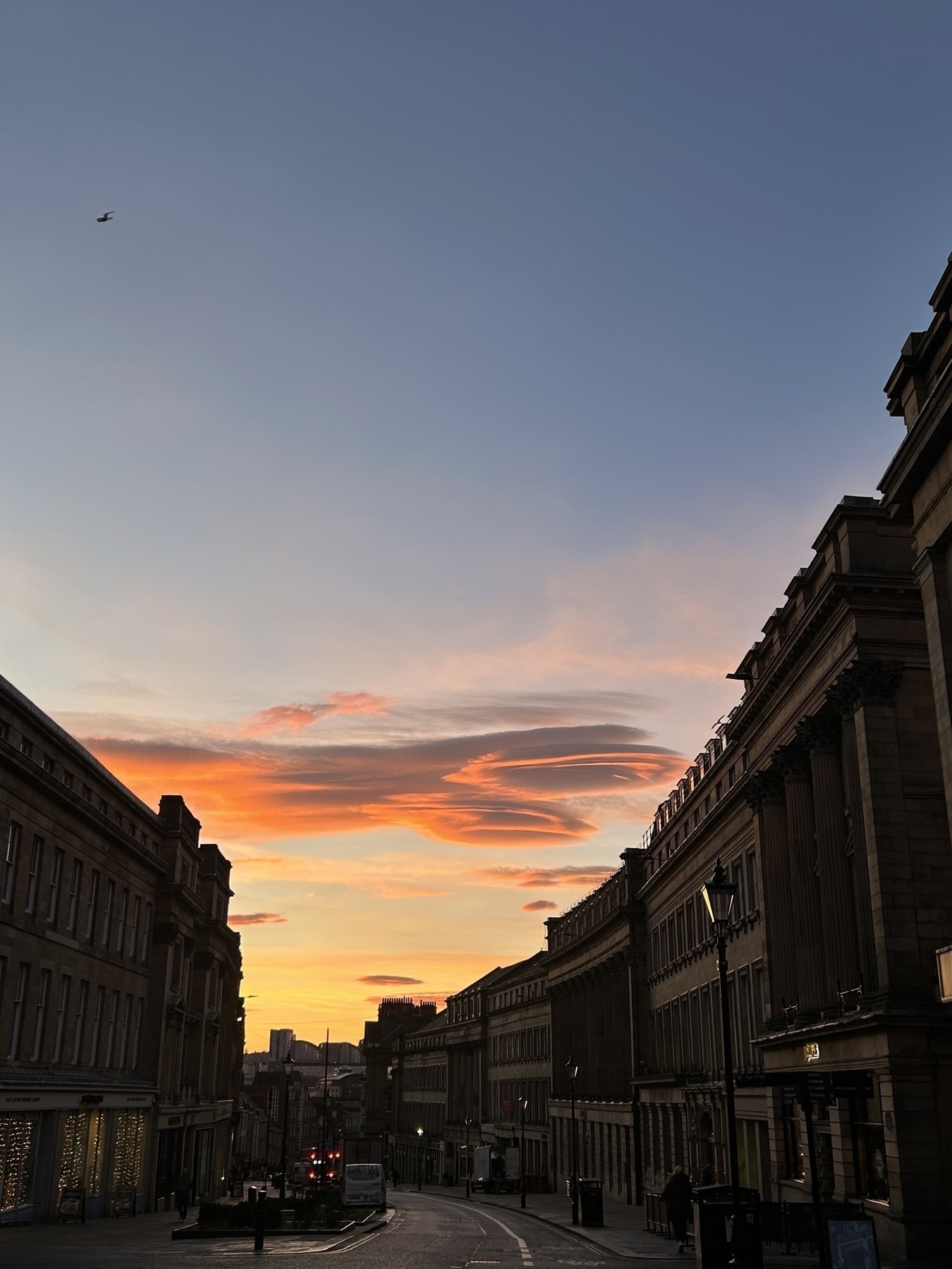 Sunrise over Newcastle’s Grey Street. Blue sky with strip of pinky-orange clouds.